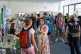 Ein Raum mit vielen Besucher*innen, im Vordergrund sind zwei Frauen zu sehen, die miteinander sprechen.
