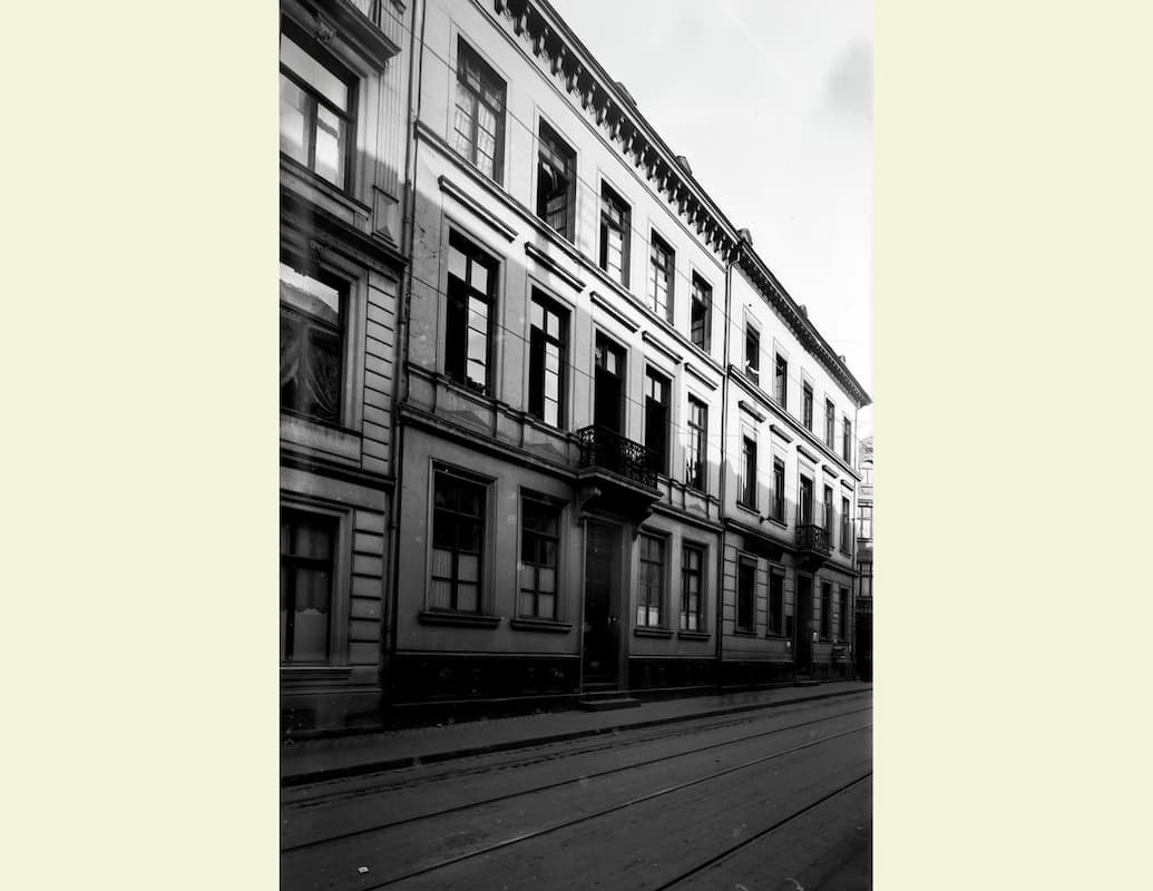 Sicht auf Häuserfassaden an einer Straße, schwarz-weißes Bild