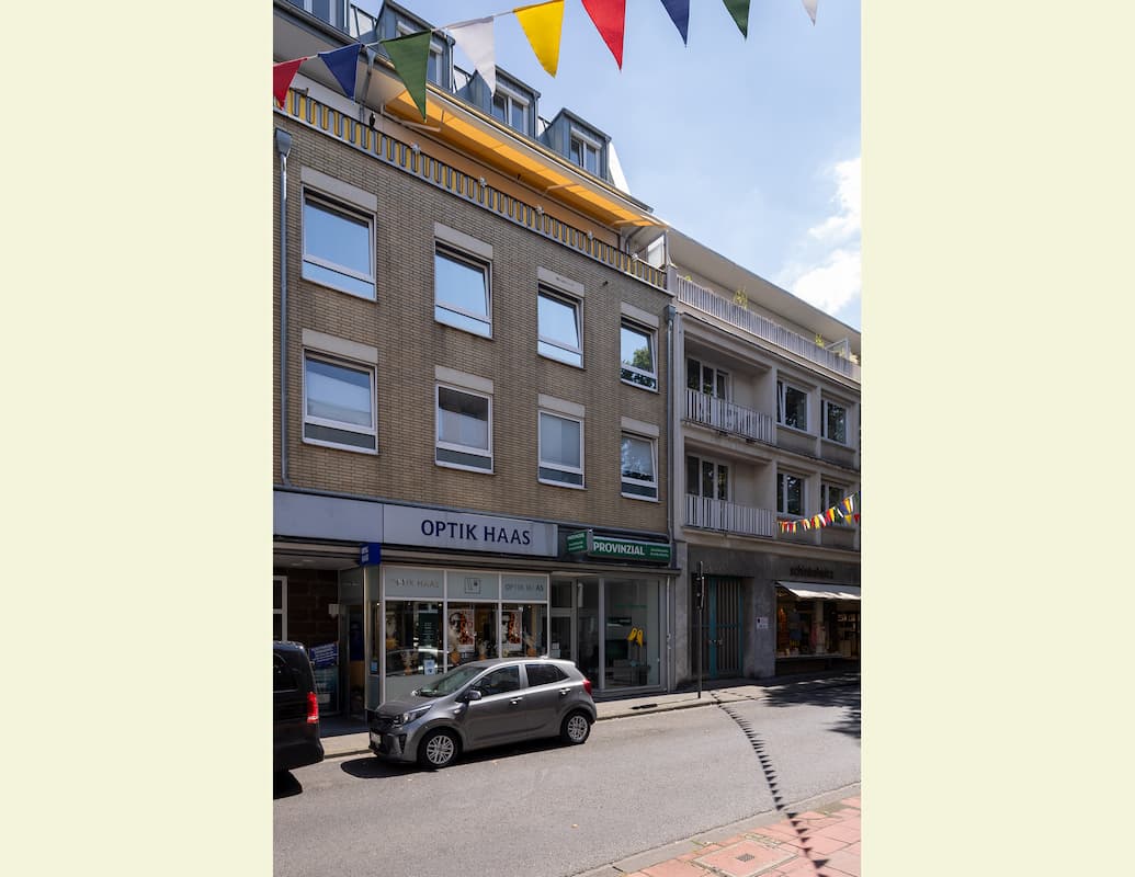 Sicht auf Häuserfassaden an einer Straße, farbiges Bild