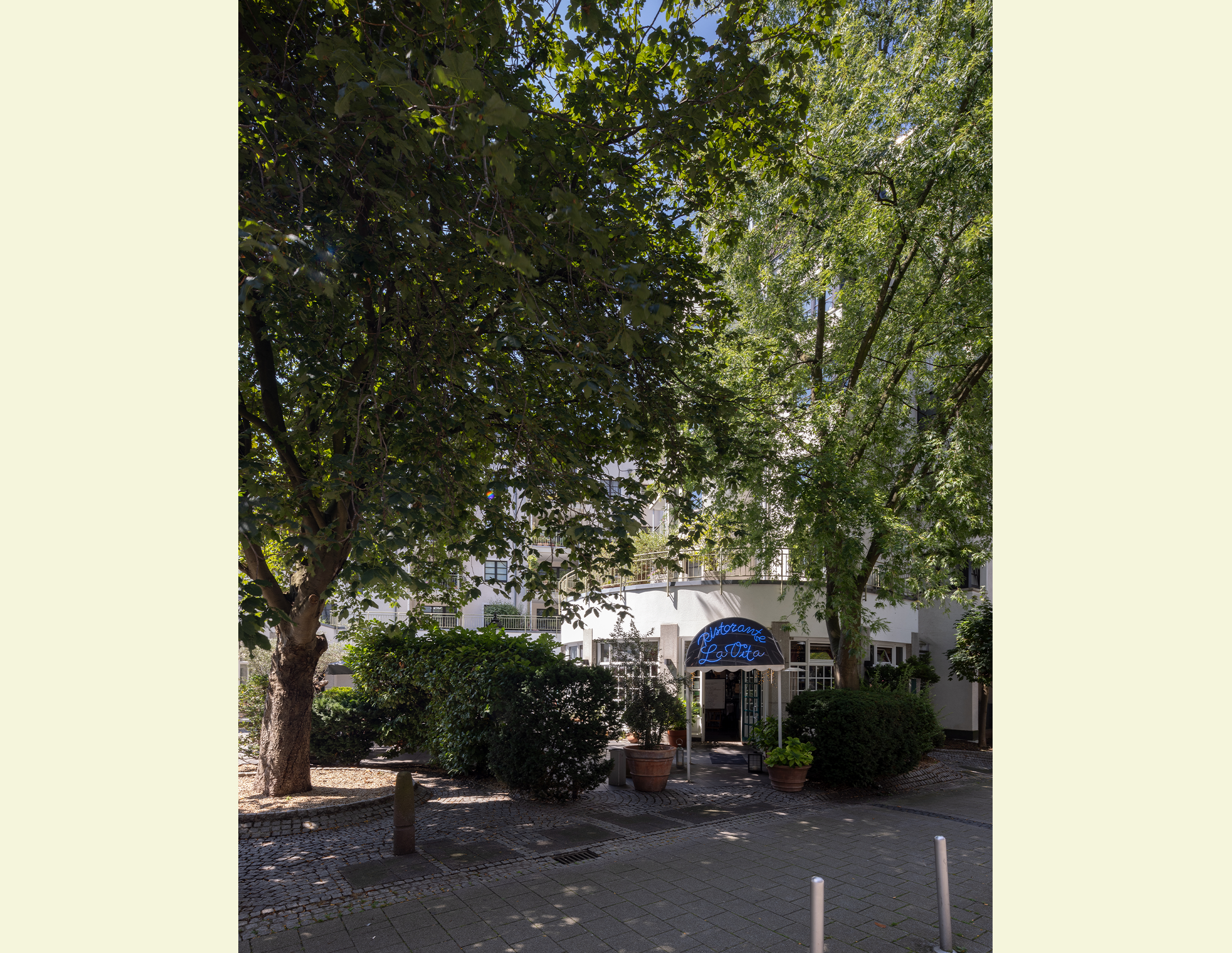 Farbiges Foto von Erich-Klibansky-Platz mit modernem Gebäude und Bäumen