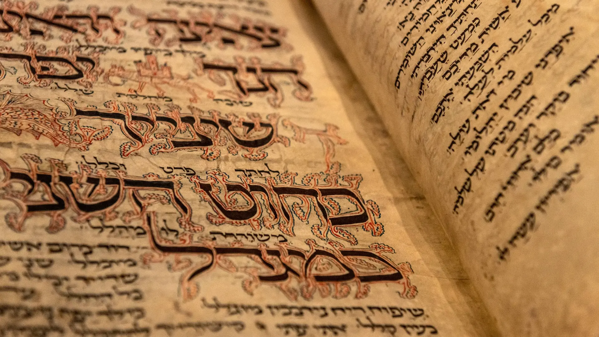 Nahaufnahme des aufgeklappten Amsterdam Machsor. Die hebräischen Textzeilen sind mit kunstvollen Zeichnungen verziert.