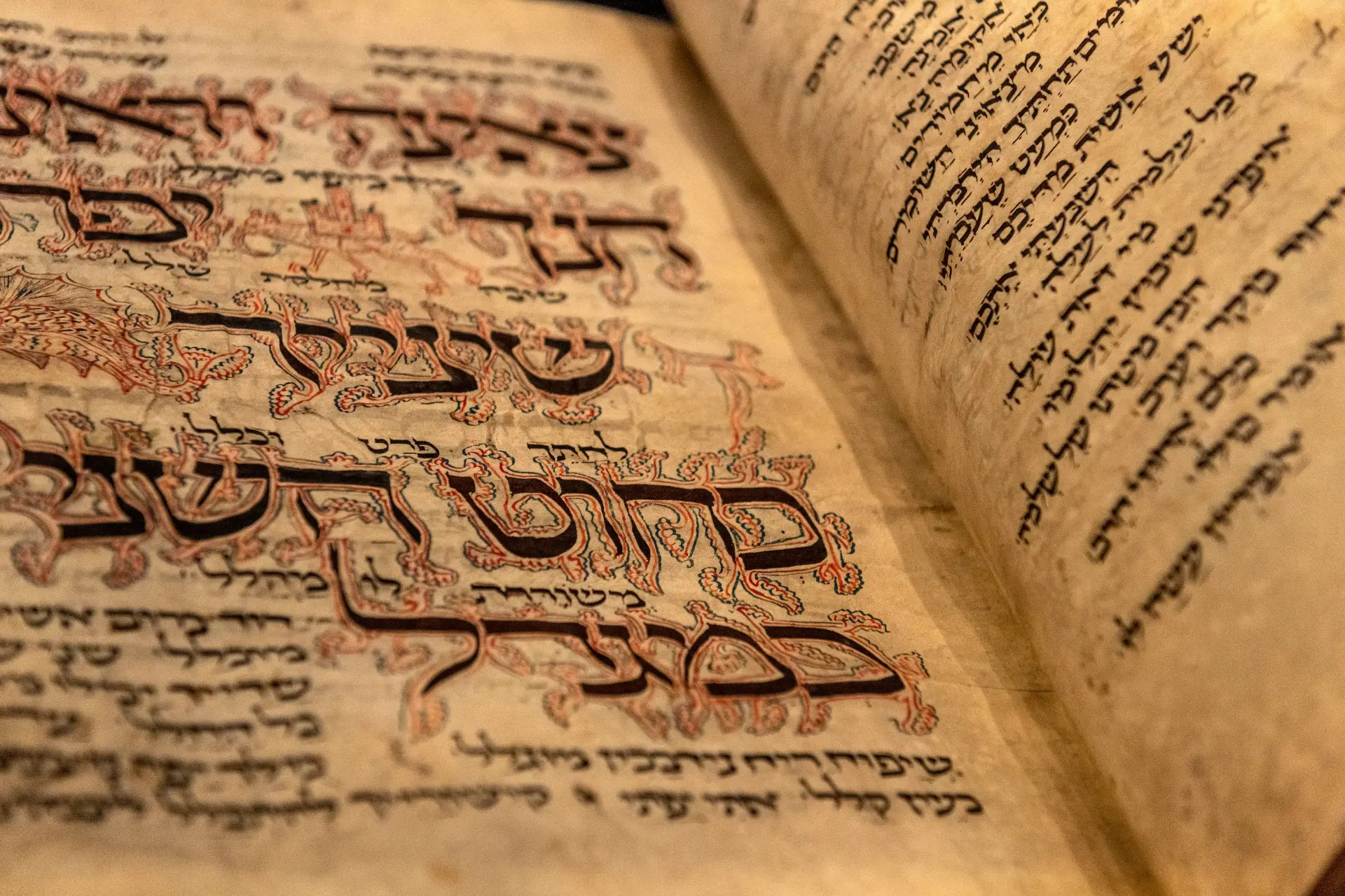 Nahaufnahme des aufgeklappten Amsterdam Machsor. Die hebräischen Textzeilen sind mit kunstvollen Zeichnungen verziert.