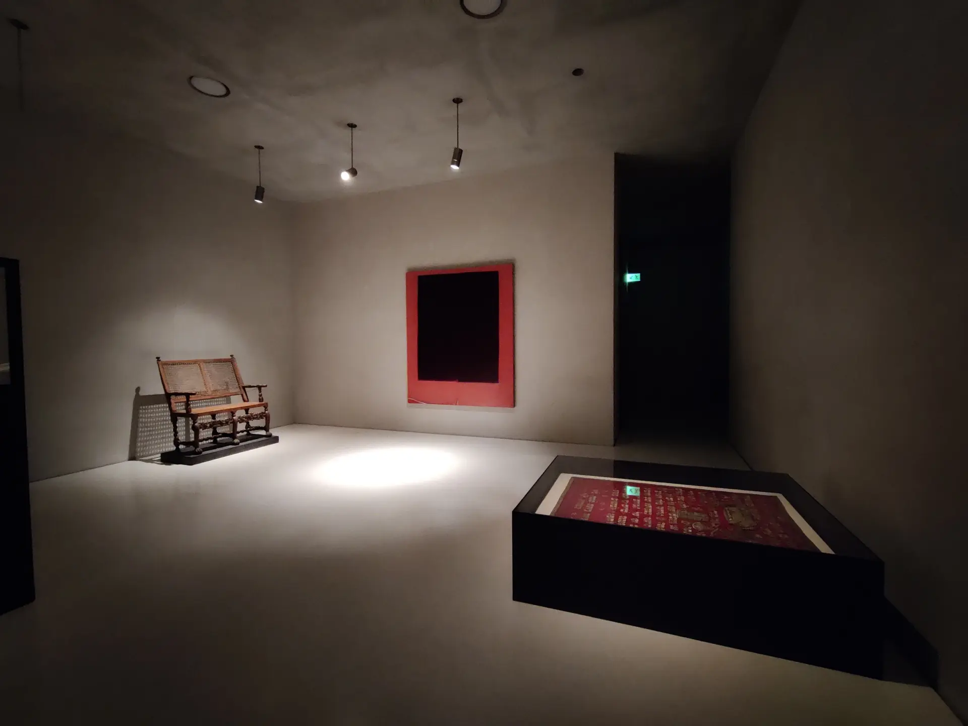 Ein weißer Raum in dem drei Ausstellungsstücke zu sehen sind.