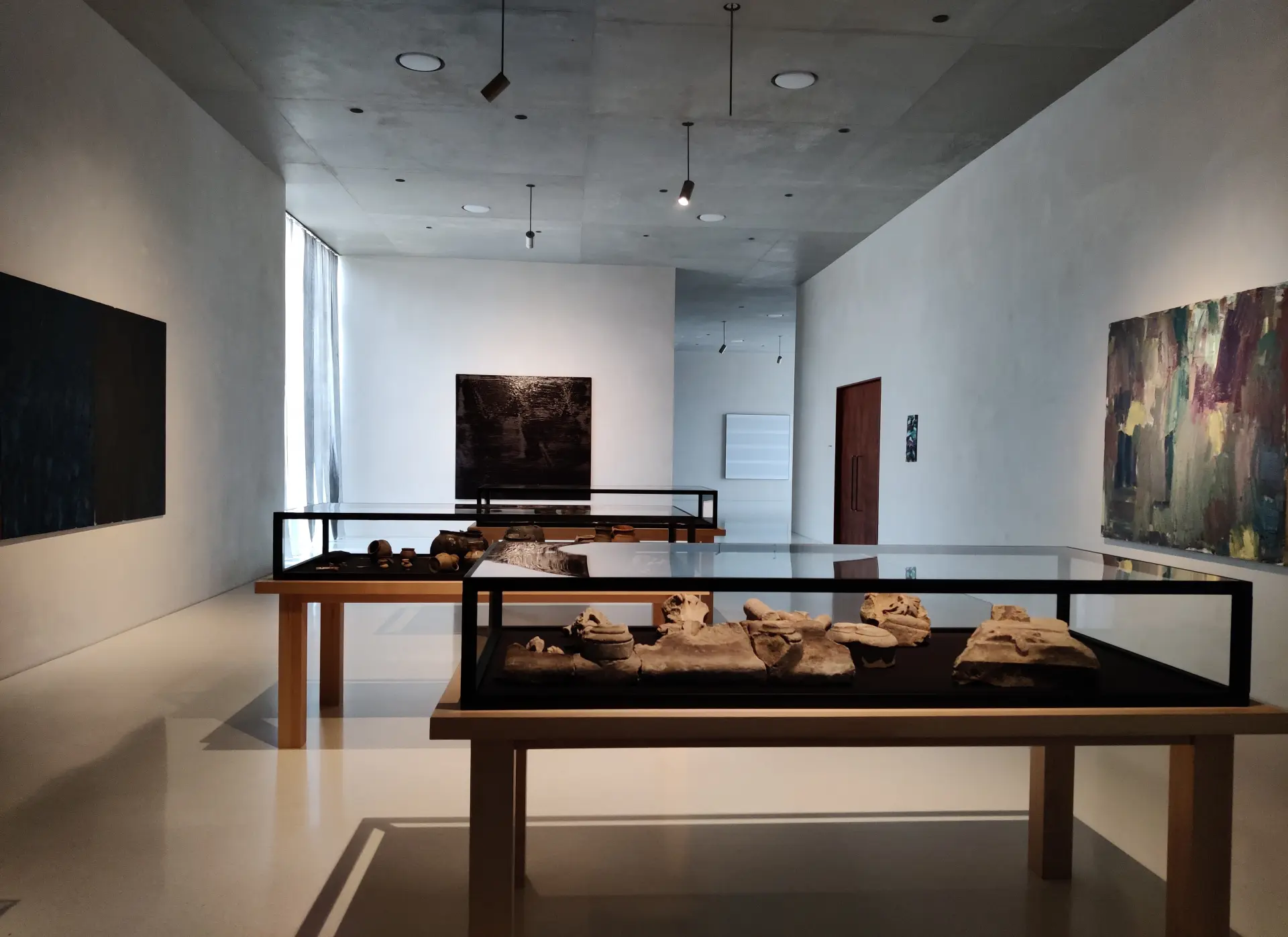 Ein Ausstellungsraum mit einer schwarzen Vitrine im Vordergrund.