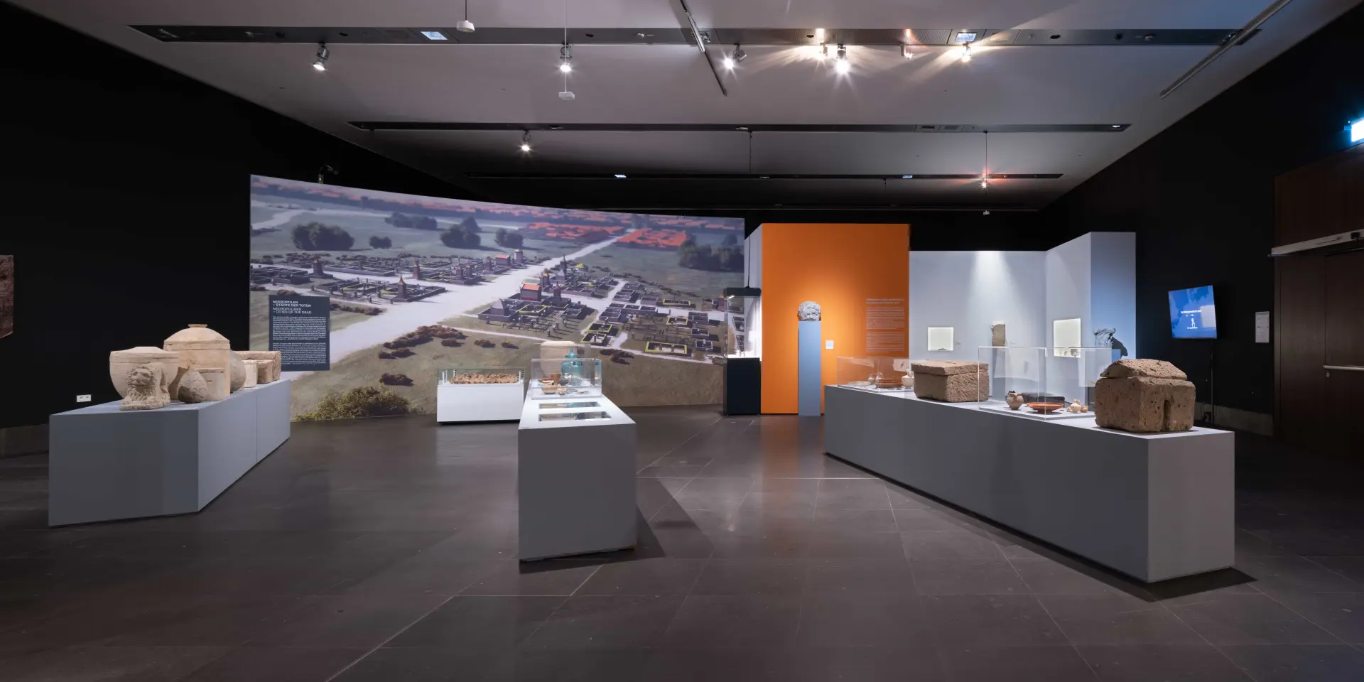 Einblick in den Raum der Ausstellung "Rom am Rhein" im Kulturzentrum am Neumarkt in Köln. Verschiedene römische Objekte werden auf Ausstellungssockel präsentiert. 