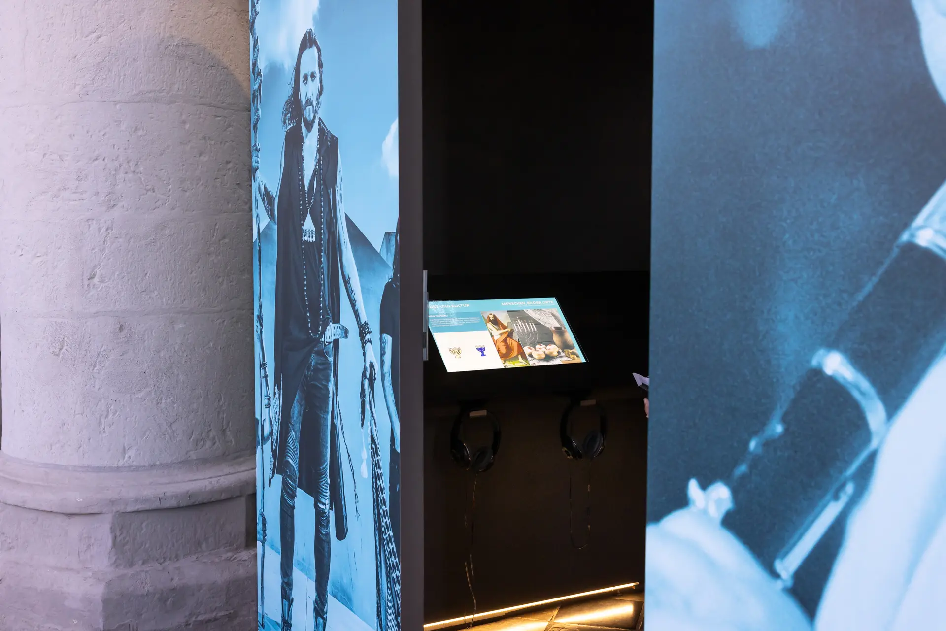 Ein Blick hinein in den blauen Ausstellungskubus. Im Innenraum des Kubus sind Displays angebracht.