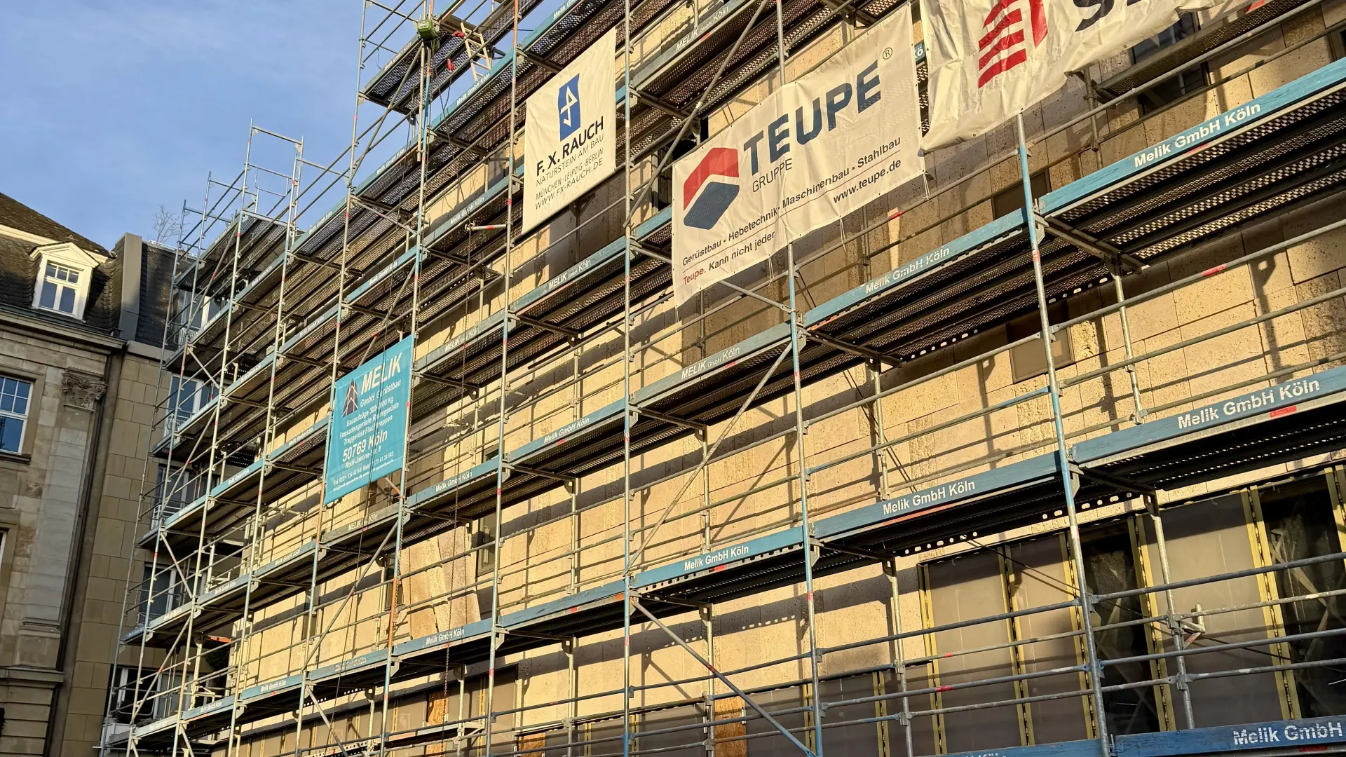 Eine Gebäude mit einer weißen Steinfassade.  Ein Baugerüst ist zu sehen.