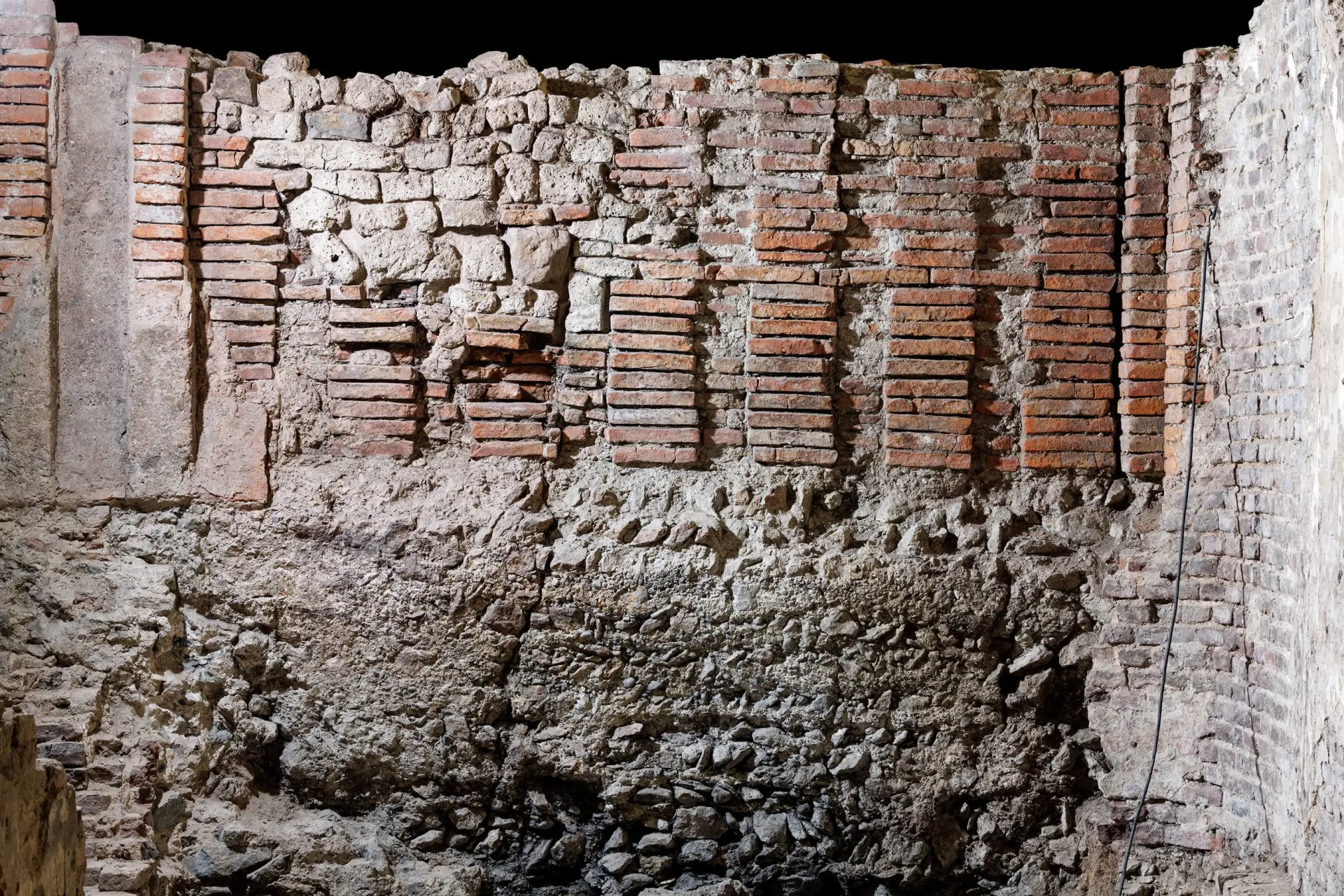 Sandfarbene und rötlich Kellerwände aus Stein.