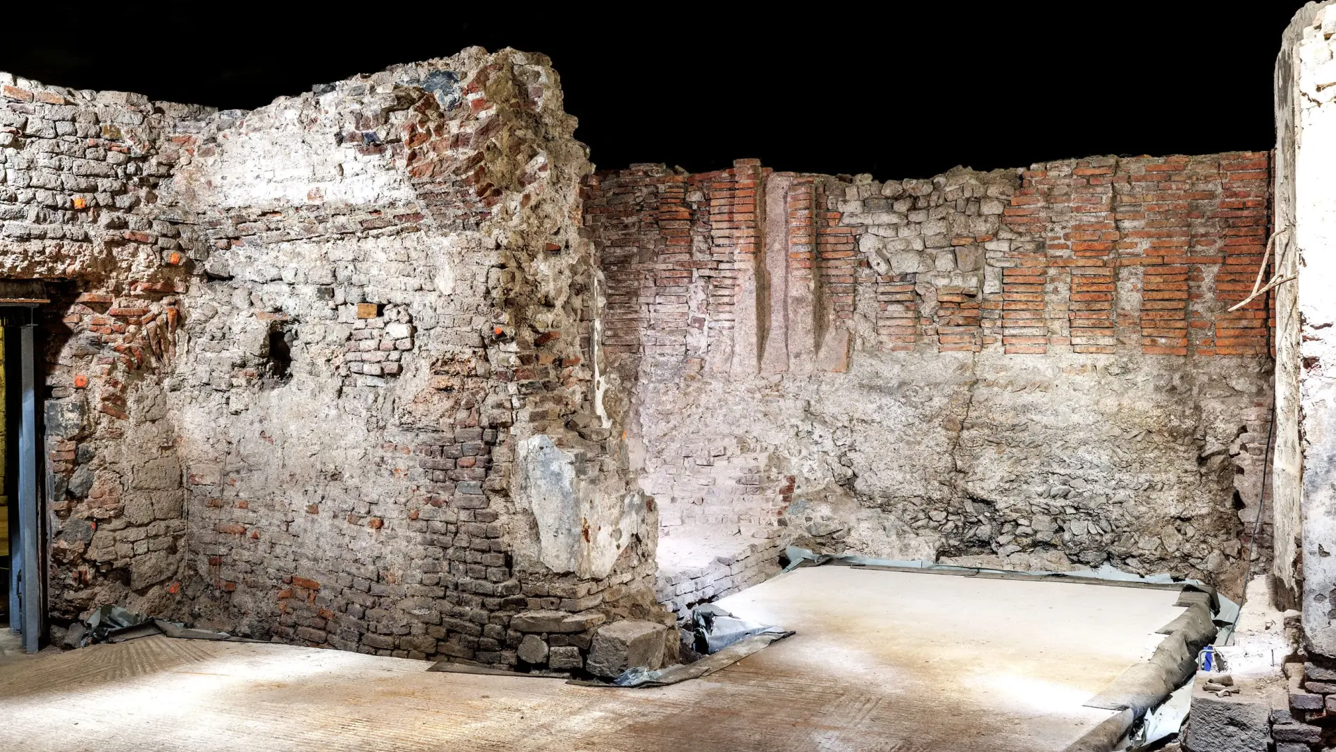 Sandfarbene und rötlich Kellerwände aus Stein.