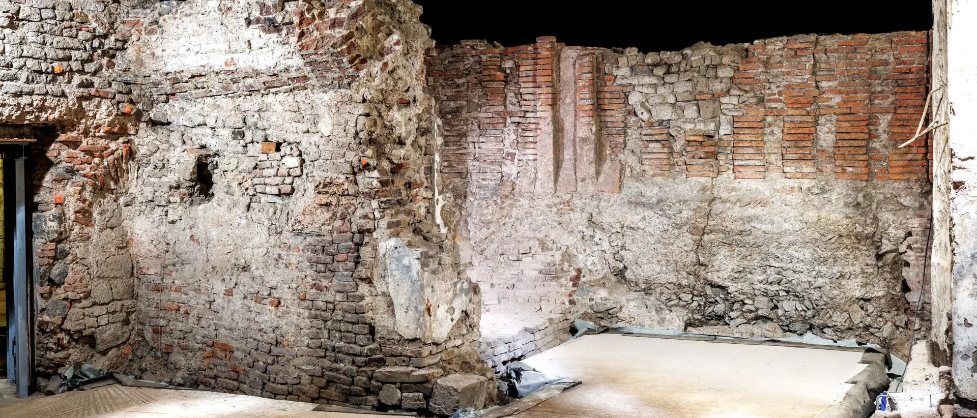 Sandfarbene und rötlich Kellerwände aus Stein.