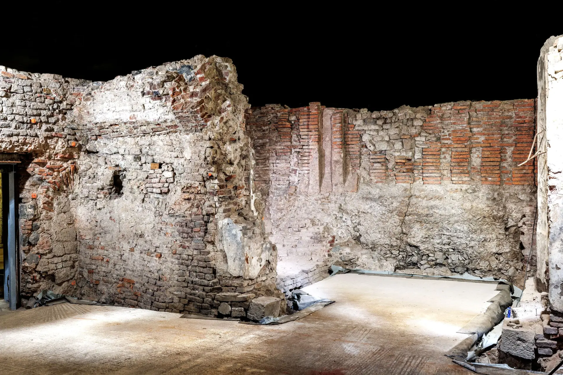 Sandfarbene und rötlich Kellerwände aus Stein.