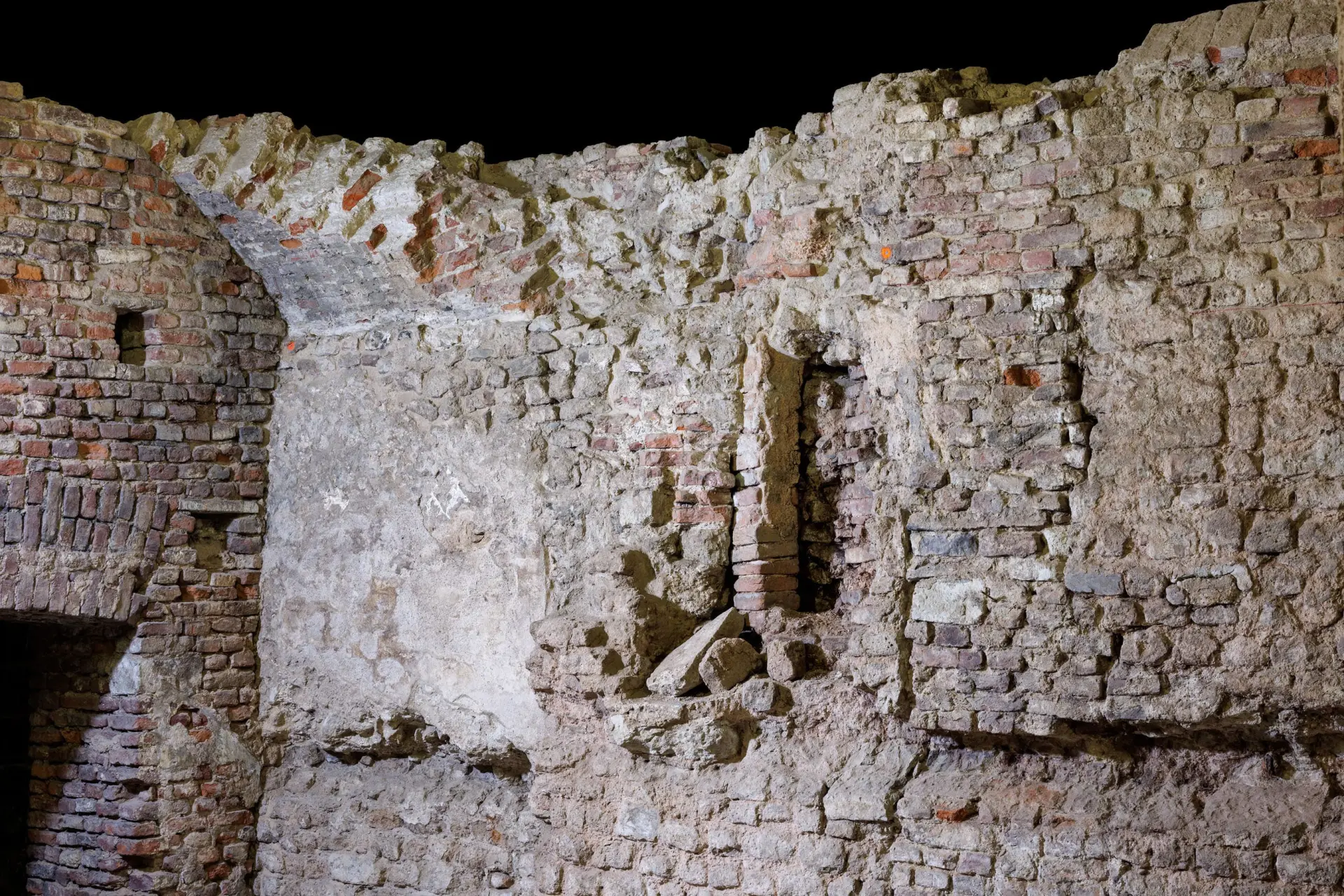 Eine Architekturzeichnung des zukünftigen Museumsgebäudes von MiQua aus der Perspektive Gülichplatz. Vor dem fertigen Museumsgebäude sind Menschen eingezeichnet, die über den Platz laufen. Links im Bild das Gebäude das Duftmuseum von Farina, rechts im Bild das Gebäude des Wallraf-Richartz-Museum. Auf dem Kölner Rathausplatz steht das Museumsgebäude von MiQua.