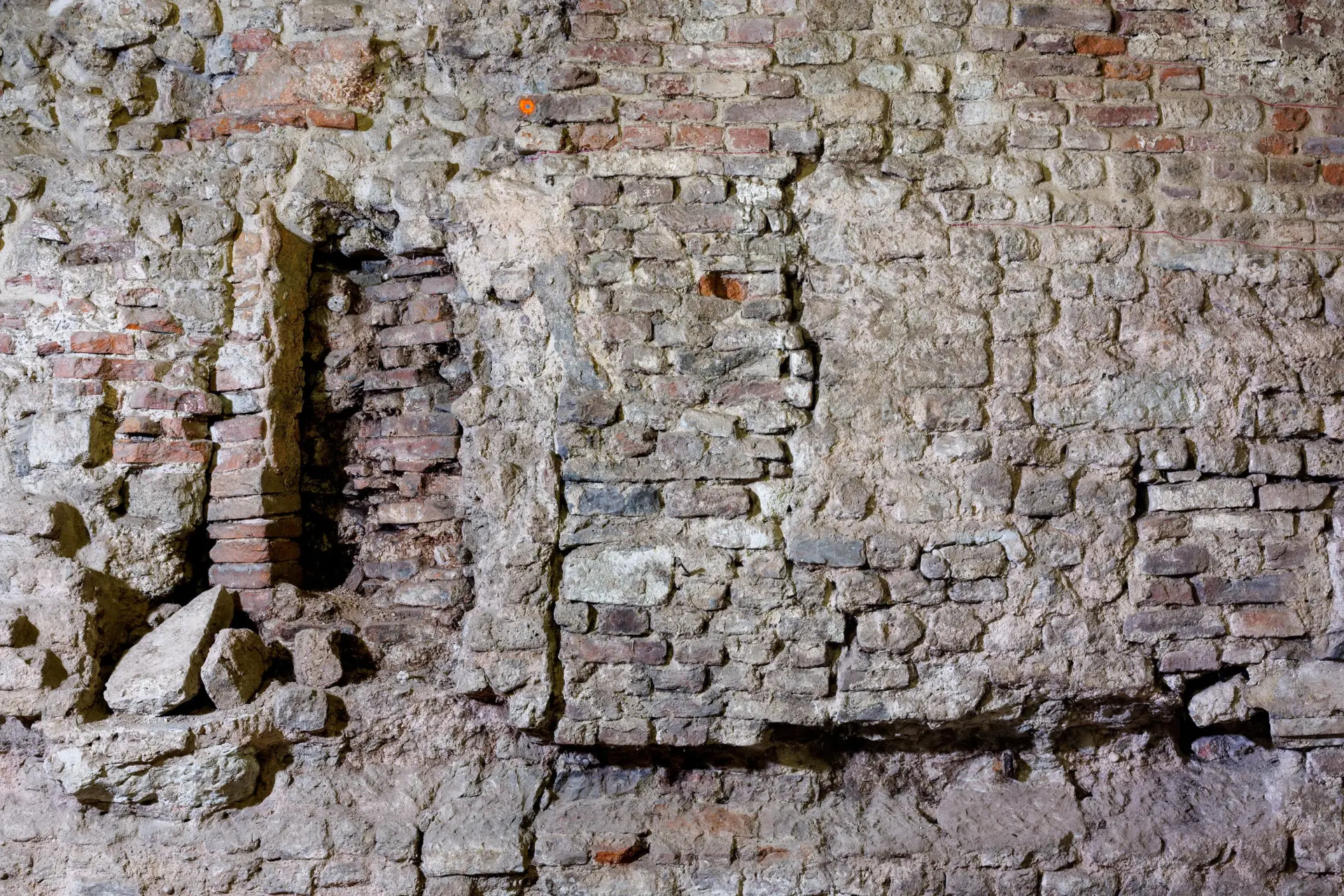 Sandfarbene und rötlich Kellerwände aus Stein.