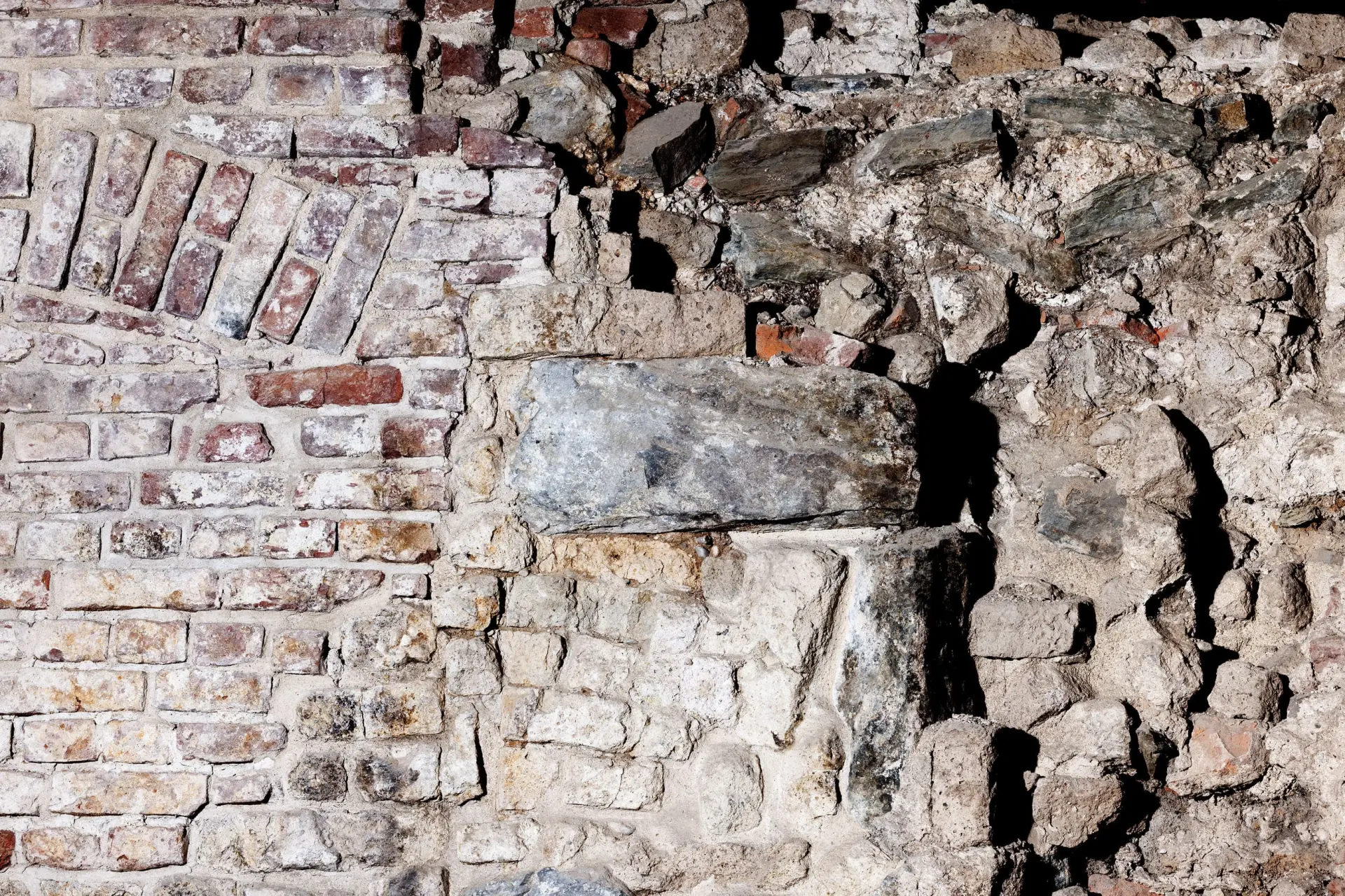 Sandfarbene und rötlich Kellerwände aus Stein.