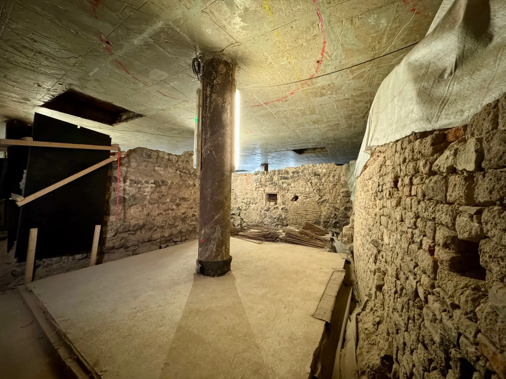 Sandsteinfarbene Kellerwände in der Ausgrabung des jüdischen Viertels.  Beleuchtet wird mit einer LED-Lichterkette