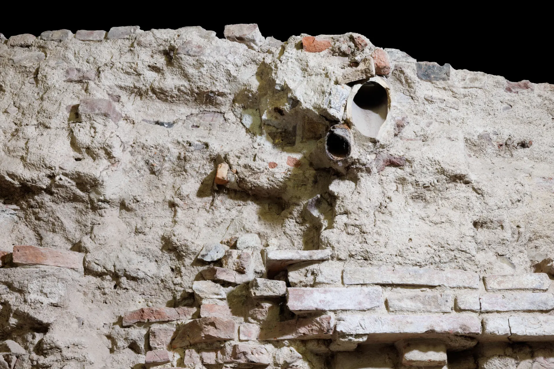 Blick auf eine graue, mittelalterliche Kellerwand.