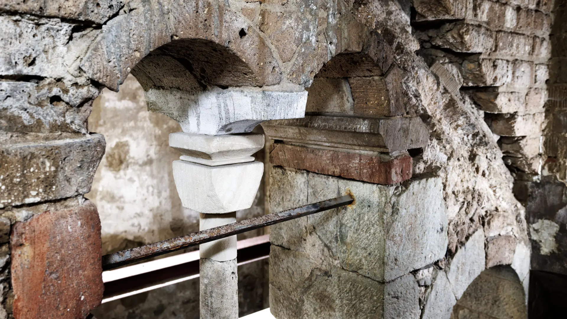 Sandfarbene und rötlich Kellerwände aus Stein.