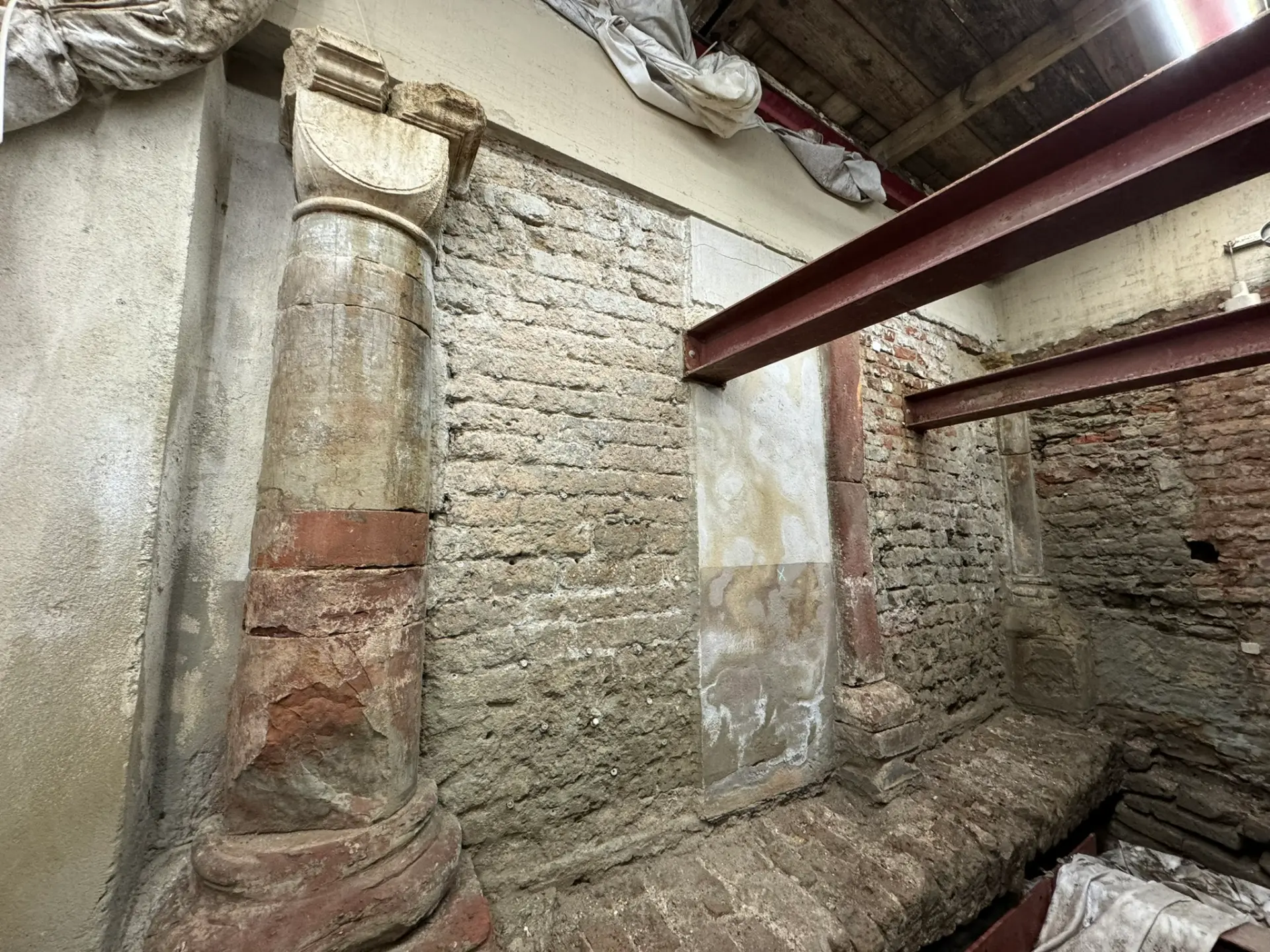 Eine Backsteinwand.  Links ist eine Säule zu sehen.