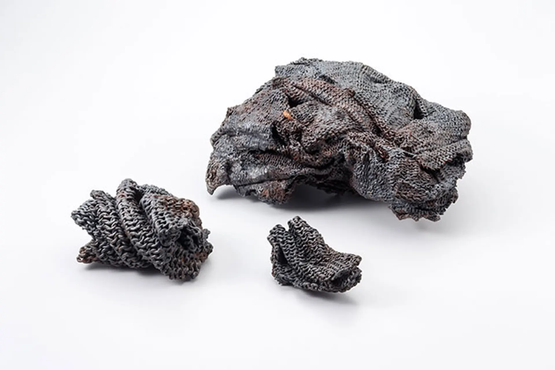 Drei schwarze Klumpen aus Metall.