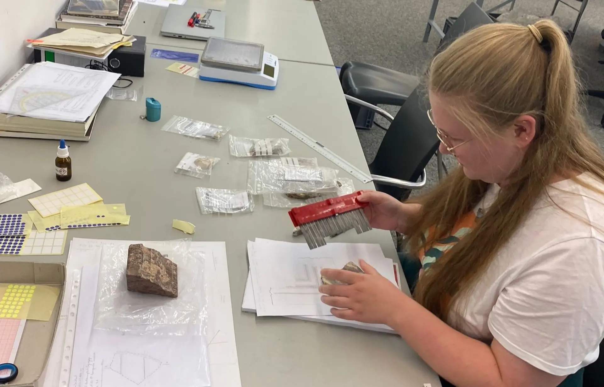 Eine Dame, die eine Inkrustation untersucht und katalogisiert.