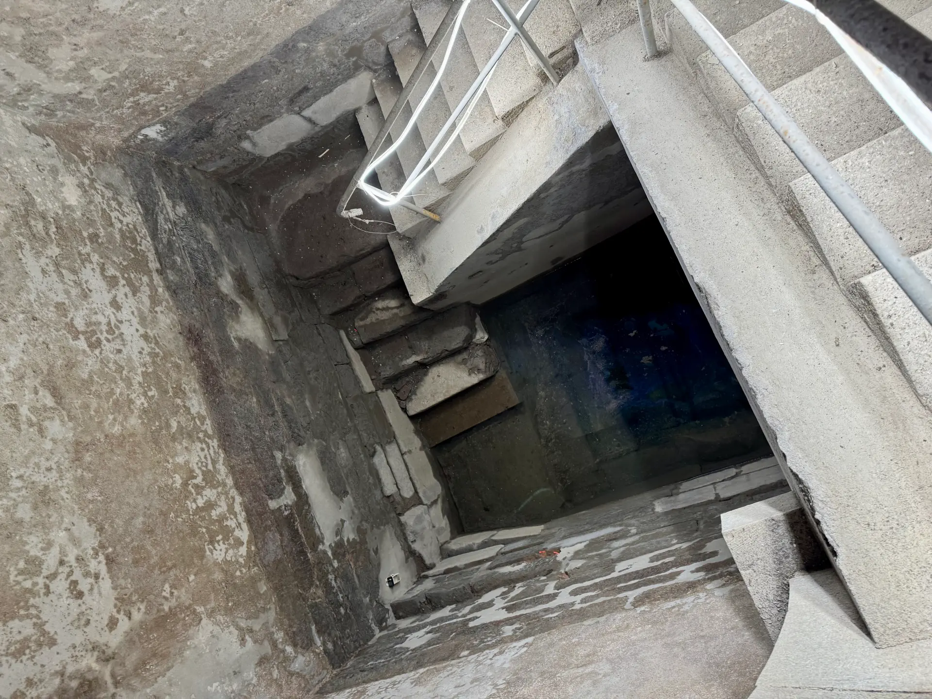 Blick in den tiefen Schacht der Kölner Monumentalmikwe von oben, mit dem Wasserbecken unten.