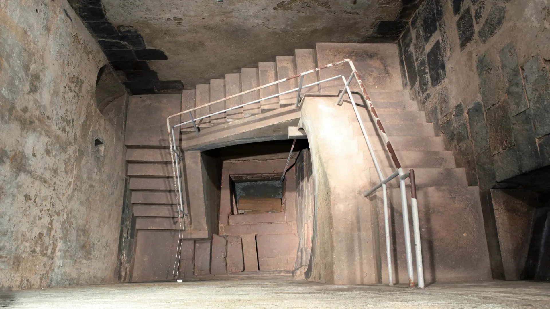 Ein Blick von oben in die Kölner Mikwe. Zu sehen sind Treppen nach unten sowie das Wasserbecken.