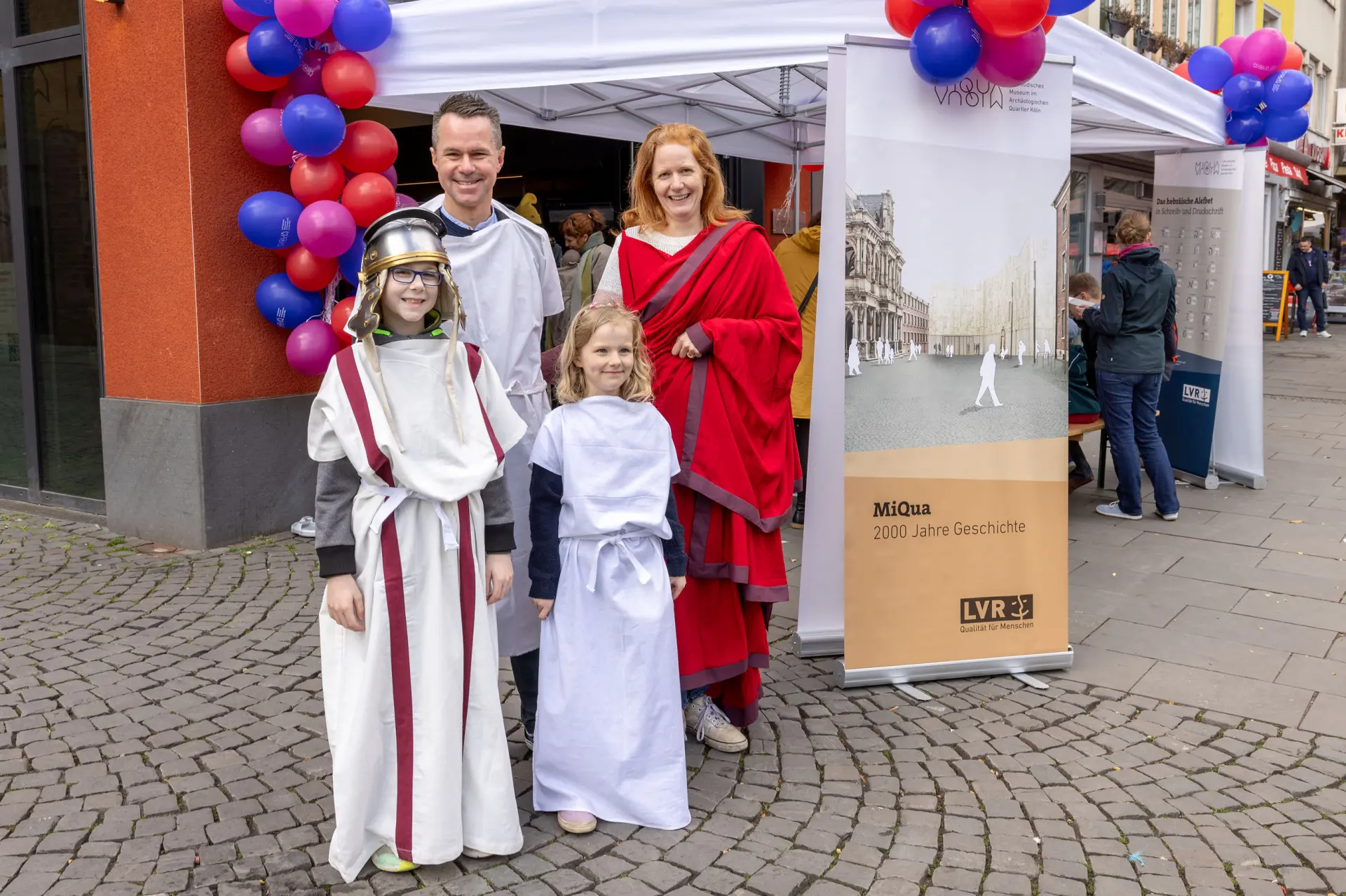 Eine Familie ist in weißen, römischen Togas verkleidet.