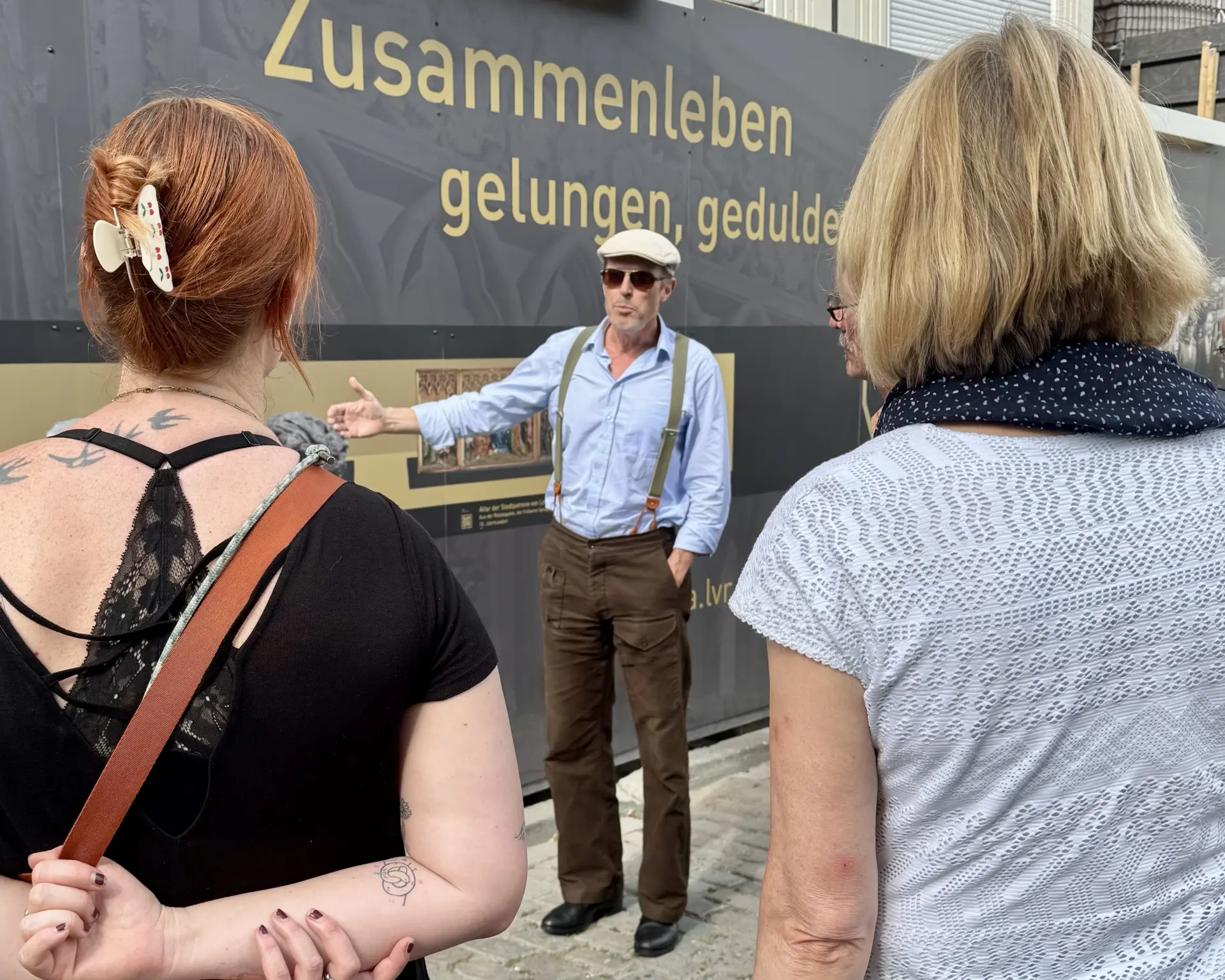 Eine Gruppe Menschen steht um einen Guide rum, der eine Stadtführung macht.