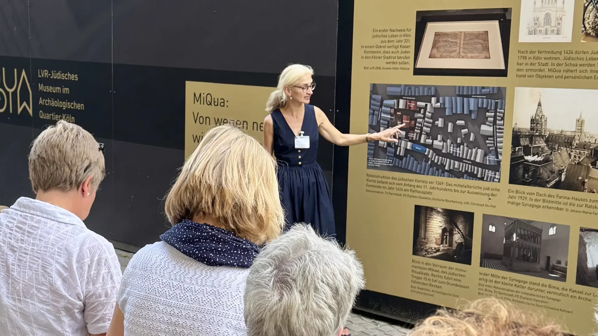 Eine Gruppe Menschen steht um einen Guide rum, der eine Stadtführung macht.