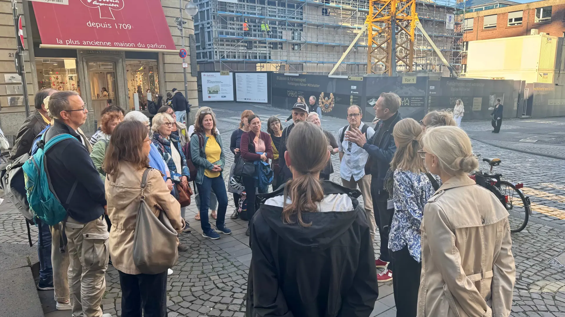 Eine Gruppe Menschen steht um einen Guide rum, der eine Stadtführung macht.