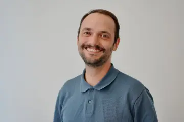 Ein junger Mann mit Bart und schwarzen Haaren.