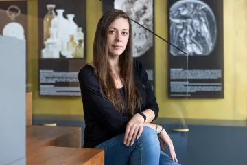  Eine Frau mit langen Haaren sitzt auf einer Treppe und lächelt in die Kamera.