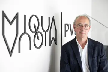 Eine Herr mit Brille und weißen Haaren lächelt in die Kamera.