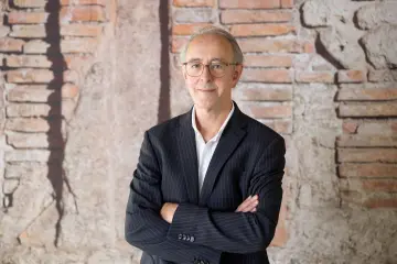 Ein Herr mit grauen Haaren und Brille blickt in die Kamera.