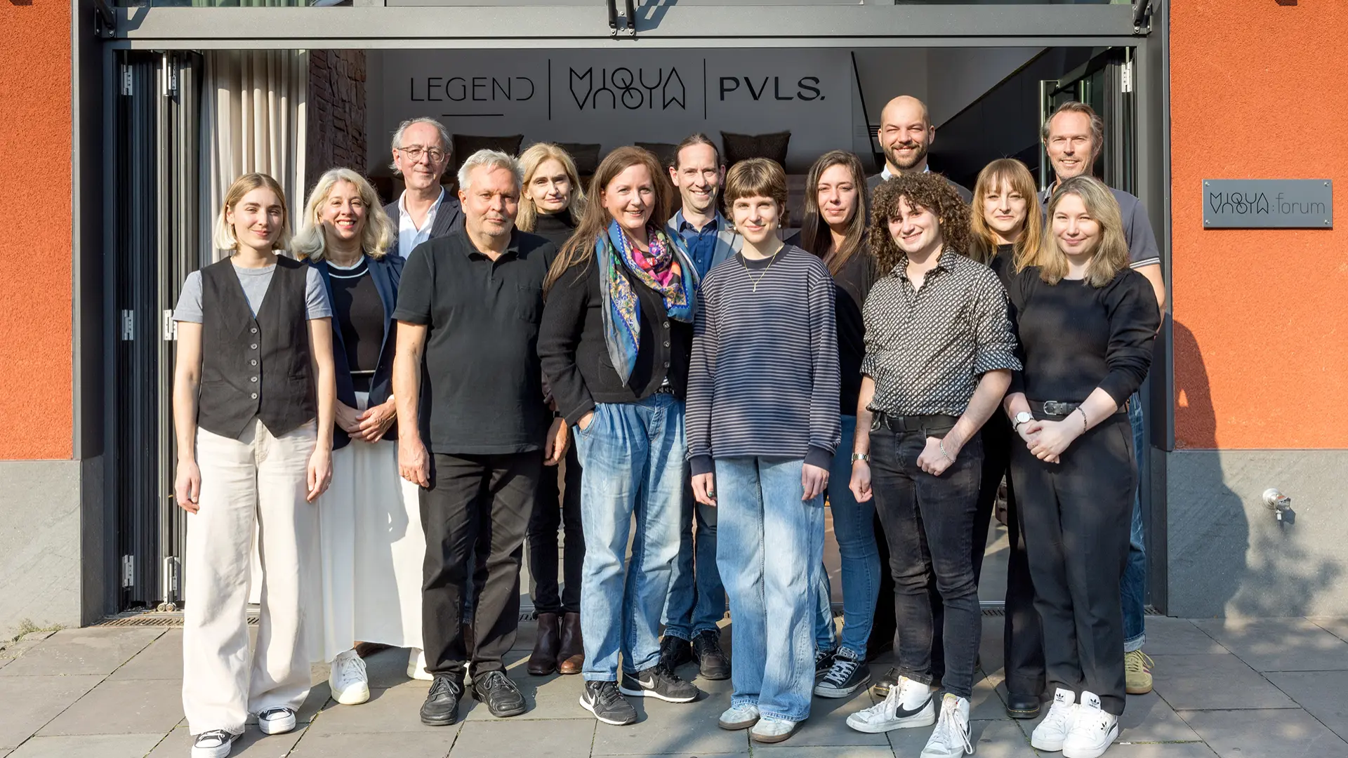 Eine Gruppe Menschen lächelt in die Kamera.