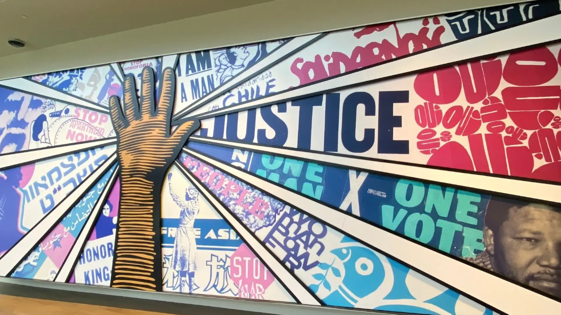 Ein buntes Grafiti mit einer erhobenen Hand und dem Wort Justice