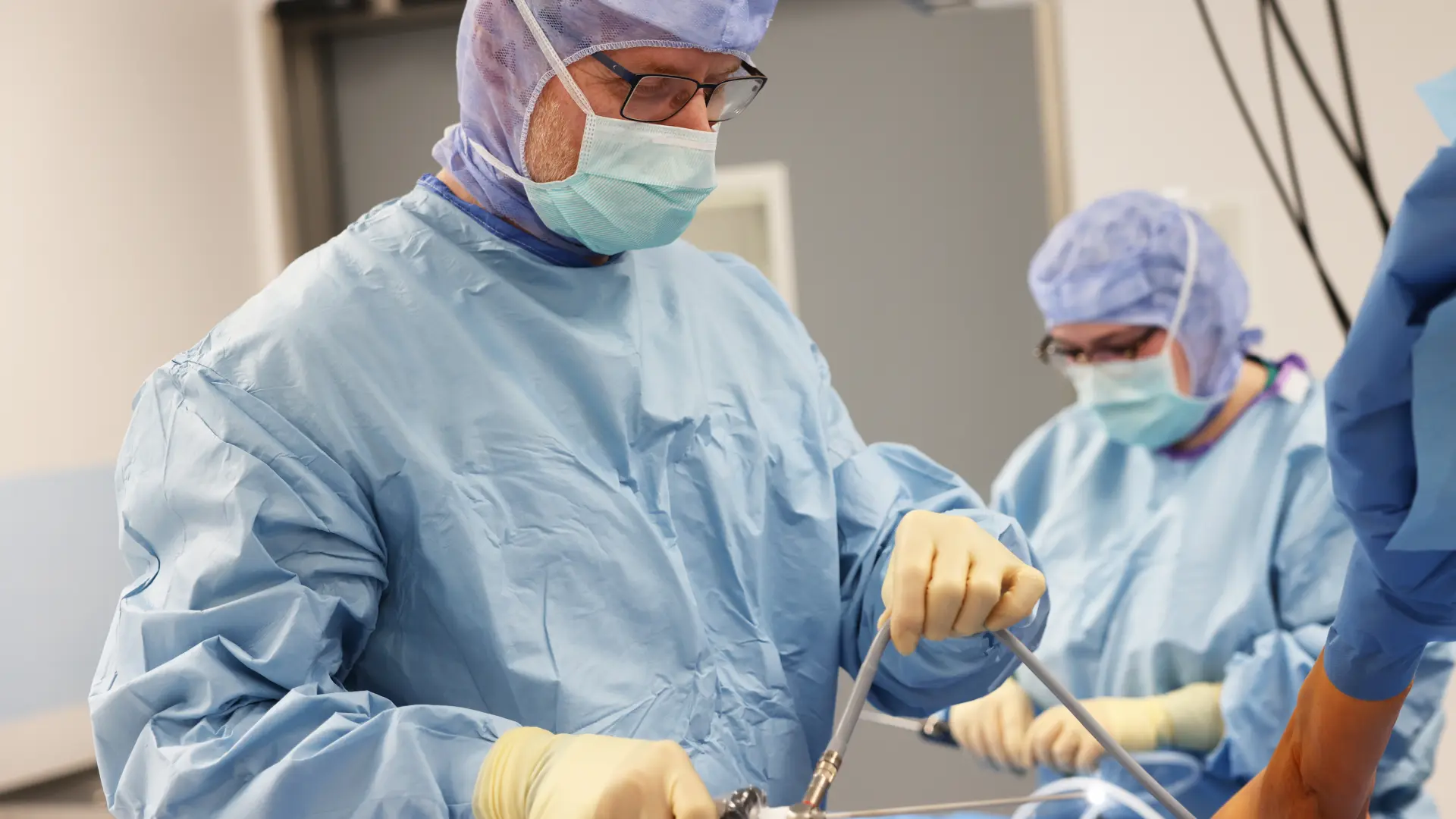 Ein Arzt und eine Assistenz, die eine Arthroskopie durchführen bei einem Patienten