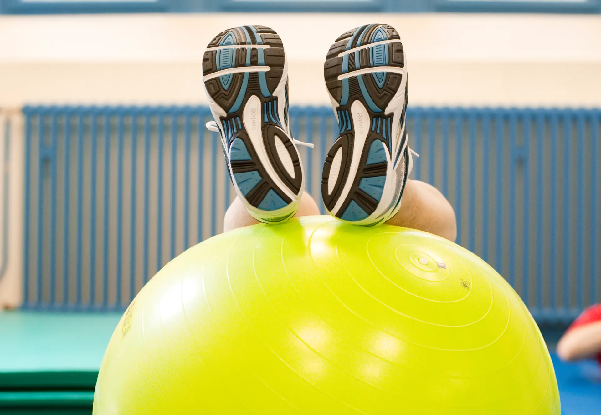 Gymnastikball mit Beinen bei der Physiotherapie