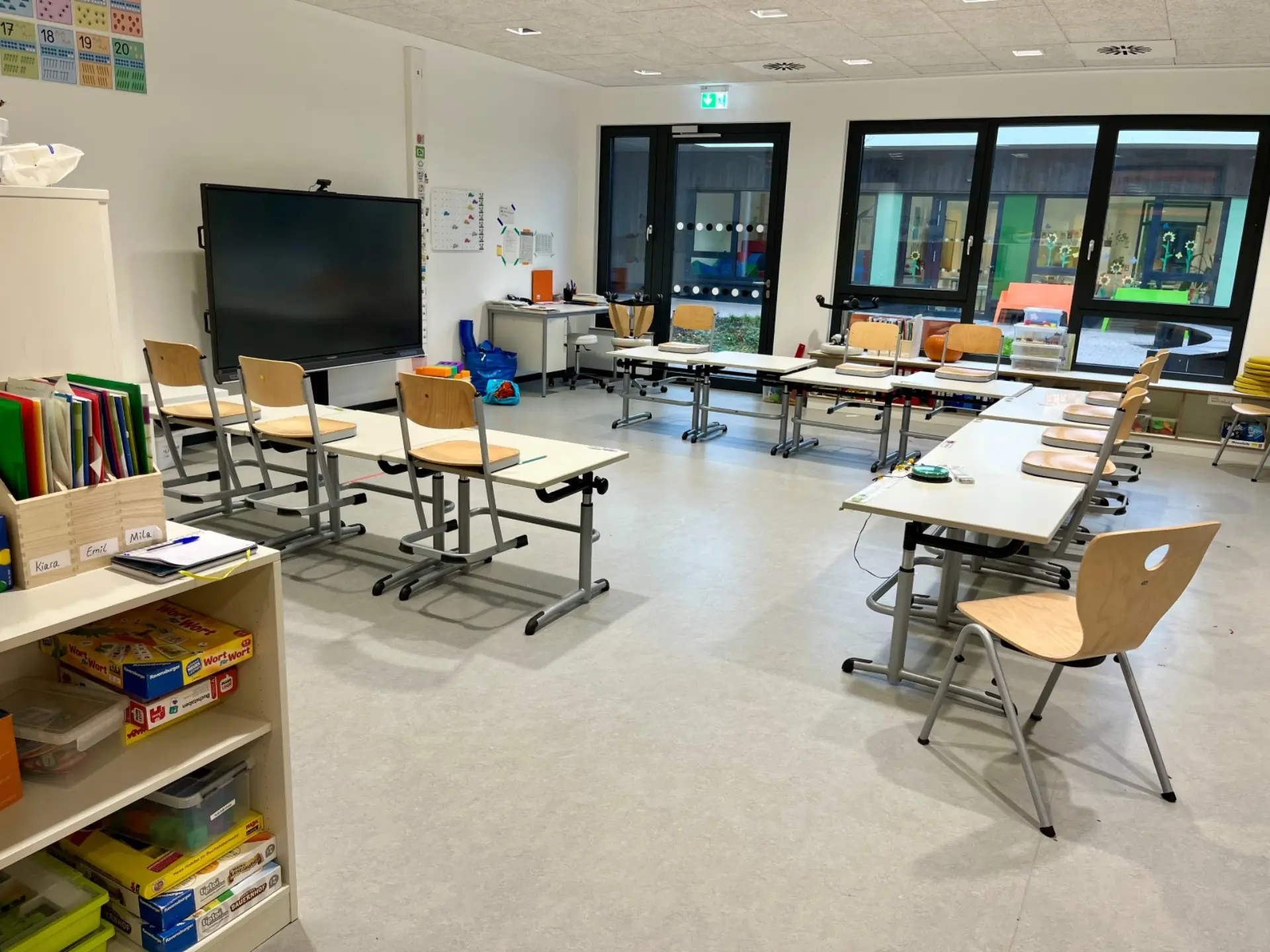 Ein heller, aufgeräumter Klassenraum mit einer digitalen Tafel