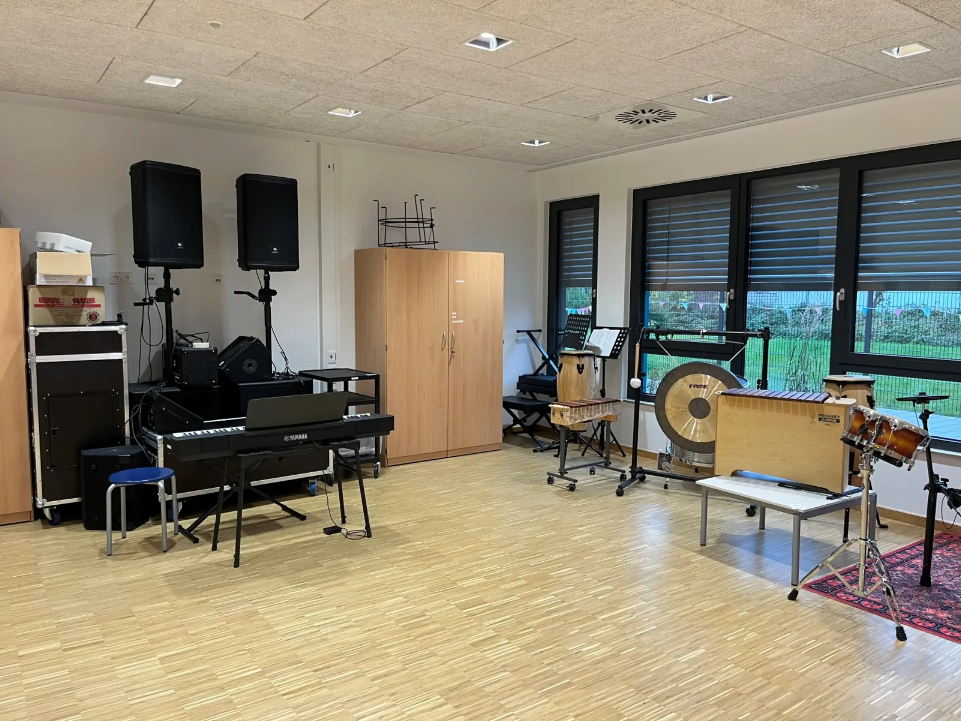 In einem Raum stehen viele Musikinstrumente und große Lautsprecherboxen