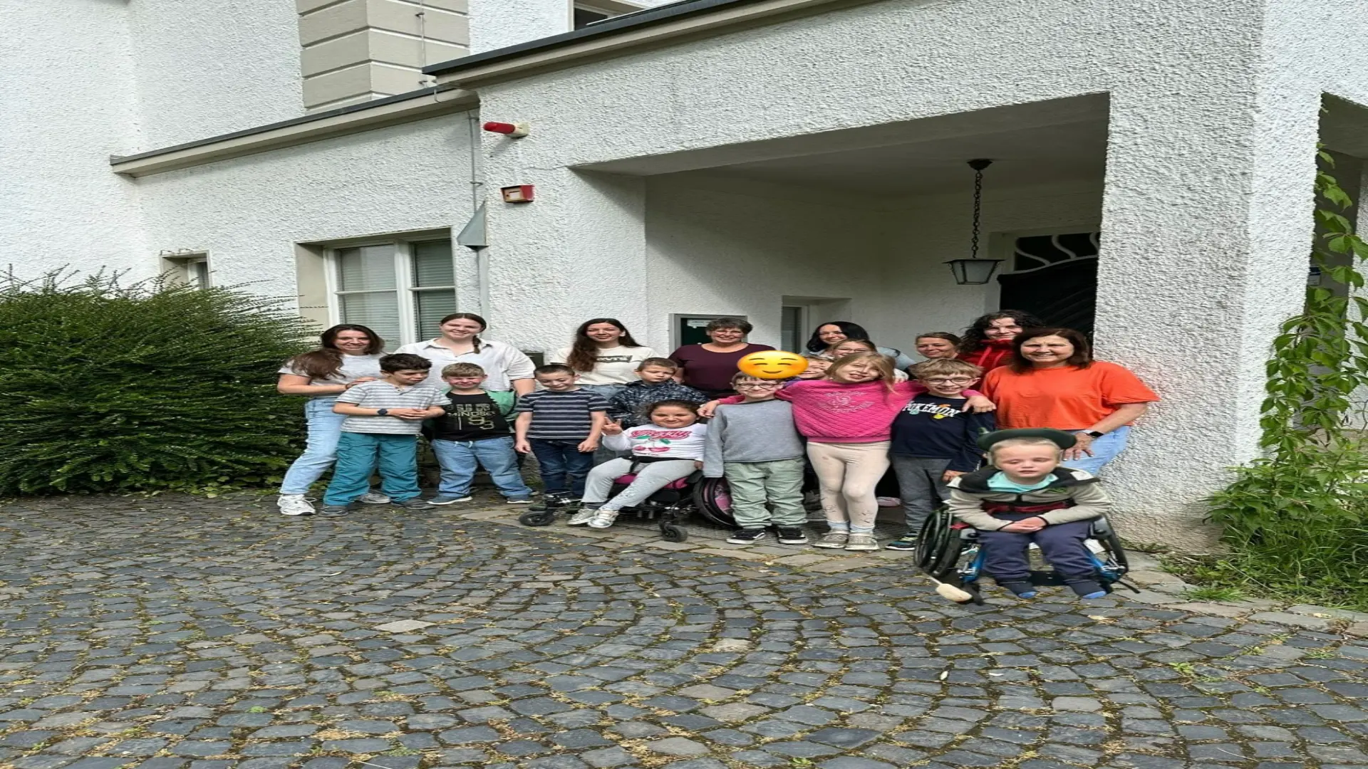 Gruppenfoto der Schildkröten und Ihrer Begleitpersonen vor einem Haus.