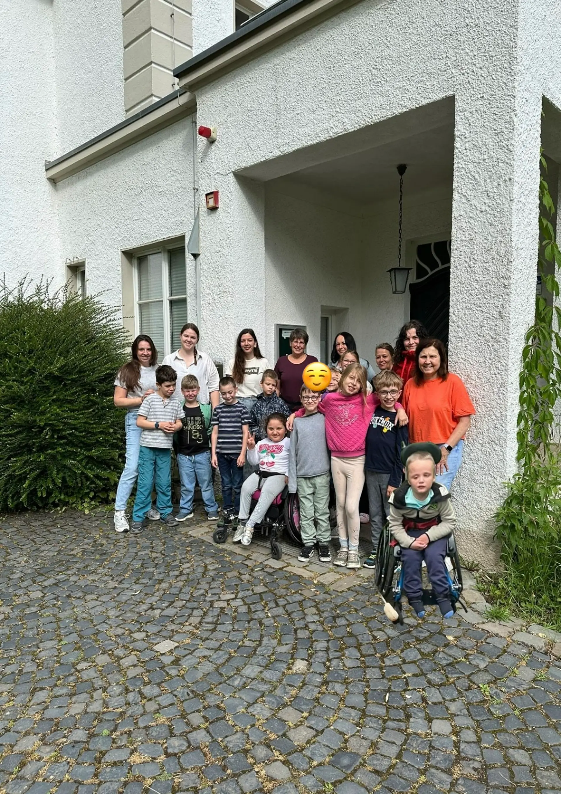Gruppenfoto der Schildkröten und Ihrer Begleitpersonen vor einem Haus.