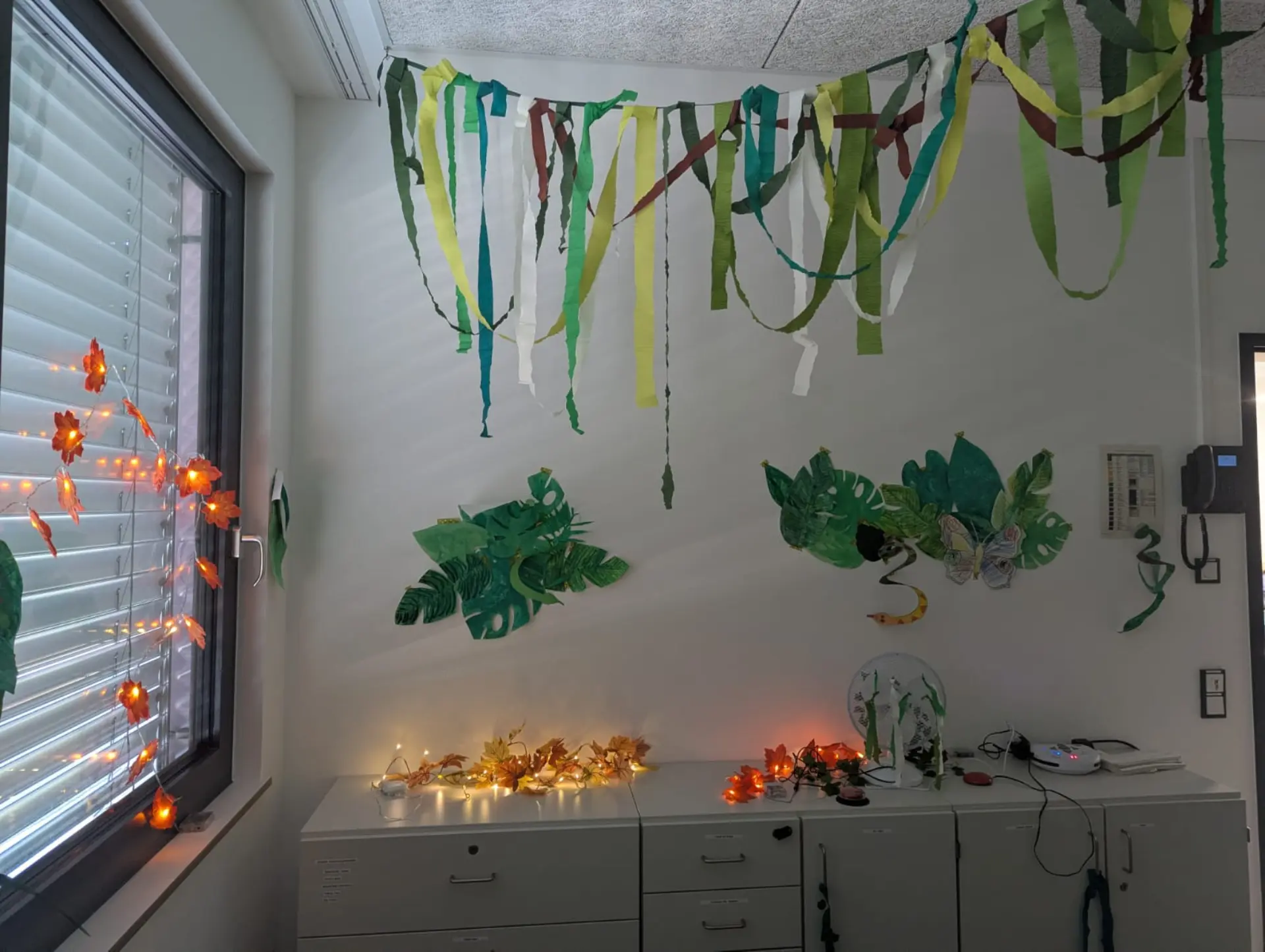 Ventilator, Lianen und Blätter aus Papier, eine Lichterkette