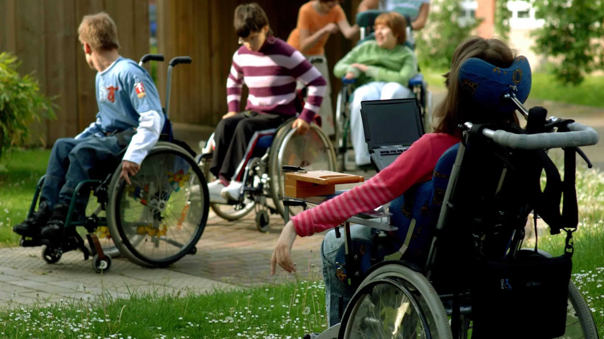 Mehrere Schüler*innen im Rollstuhl auf dem Schulhof