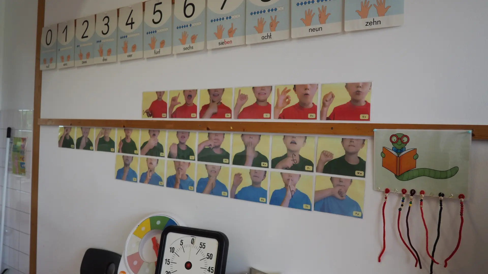 Plakate mit Gebärden und Zahlen an der Wand