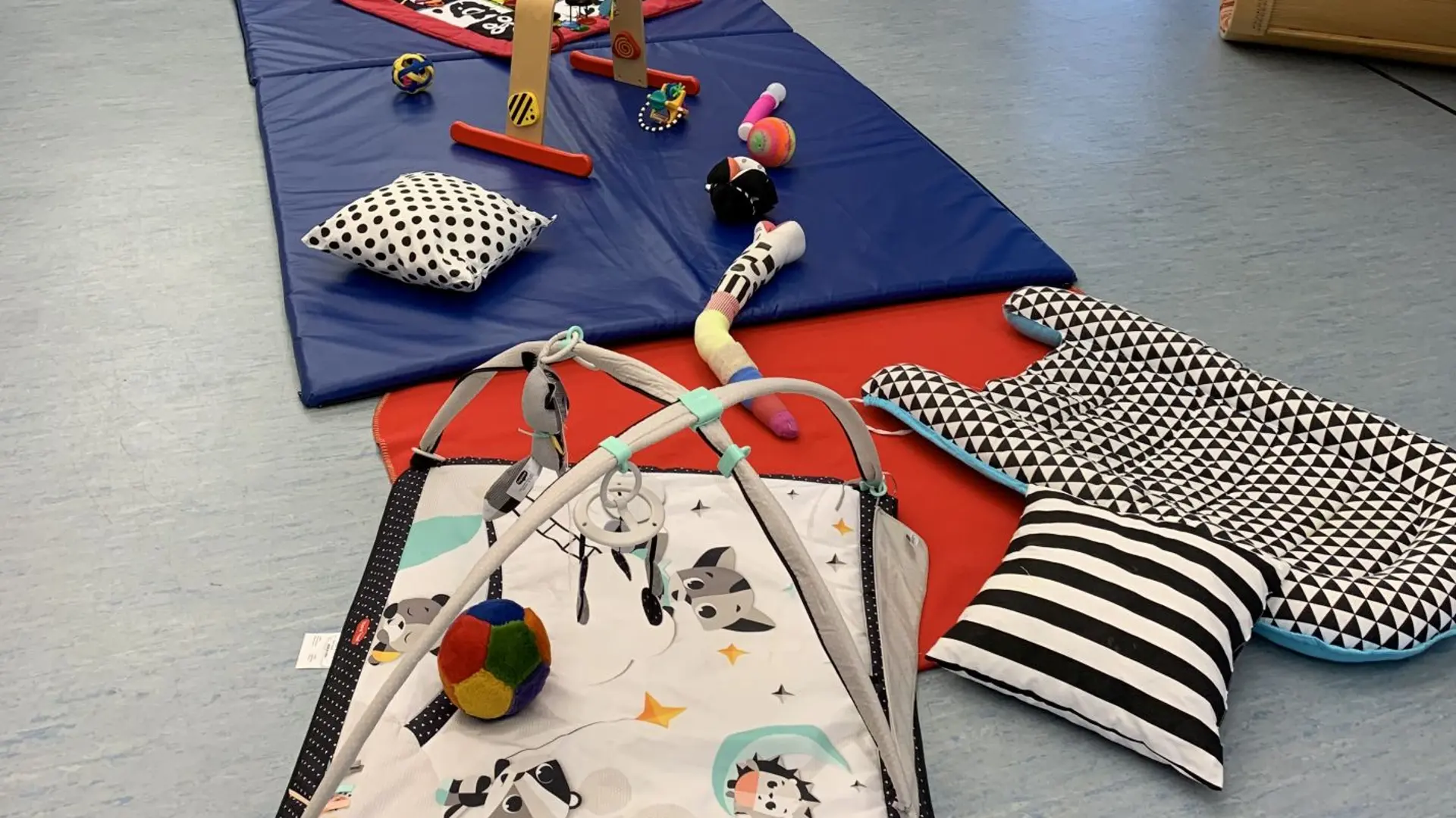 Im Bewegungsraum des Frühförderzentrums liegen kontrastreiche Spielmaterialien für Babys.