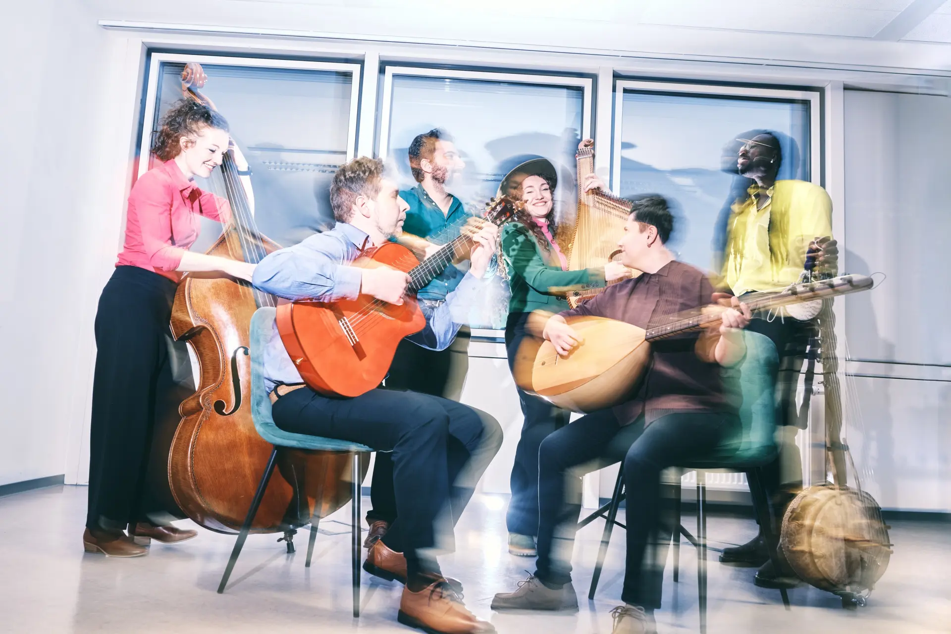 Das Bild zeigt die Gruppe Tiny Bridges mit ihren Instrumenten auf den Zuschauersitzen.