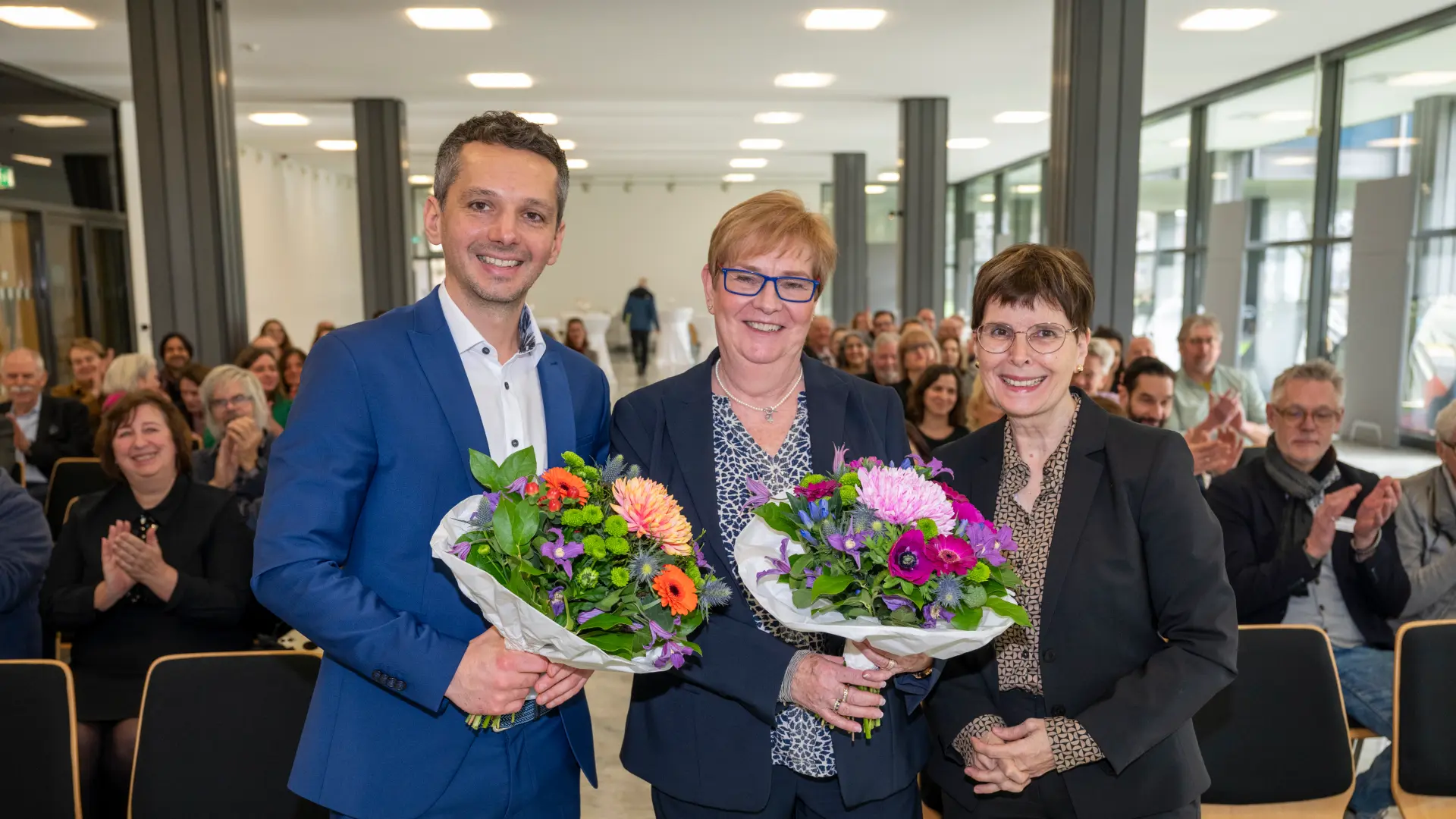 Alexander Rollmann, Brigitte Balzer und Martina Wenzel-Jankowski stehen zusammen und lächeln in die Kamera.