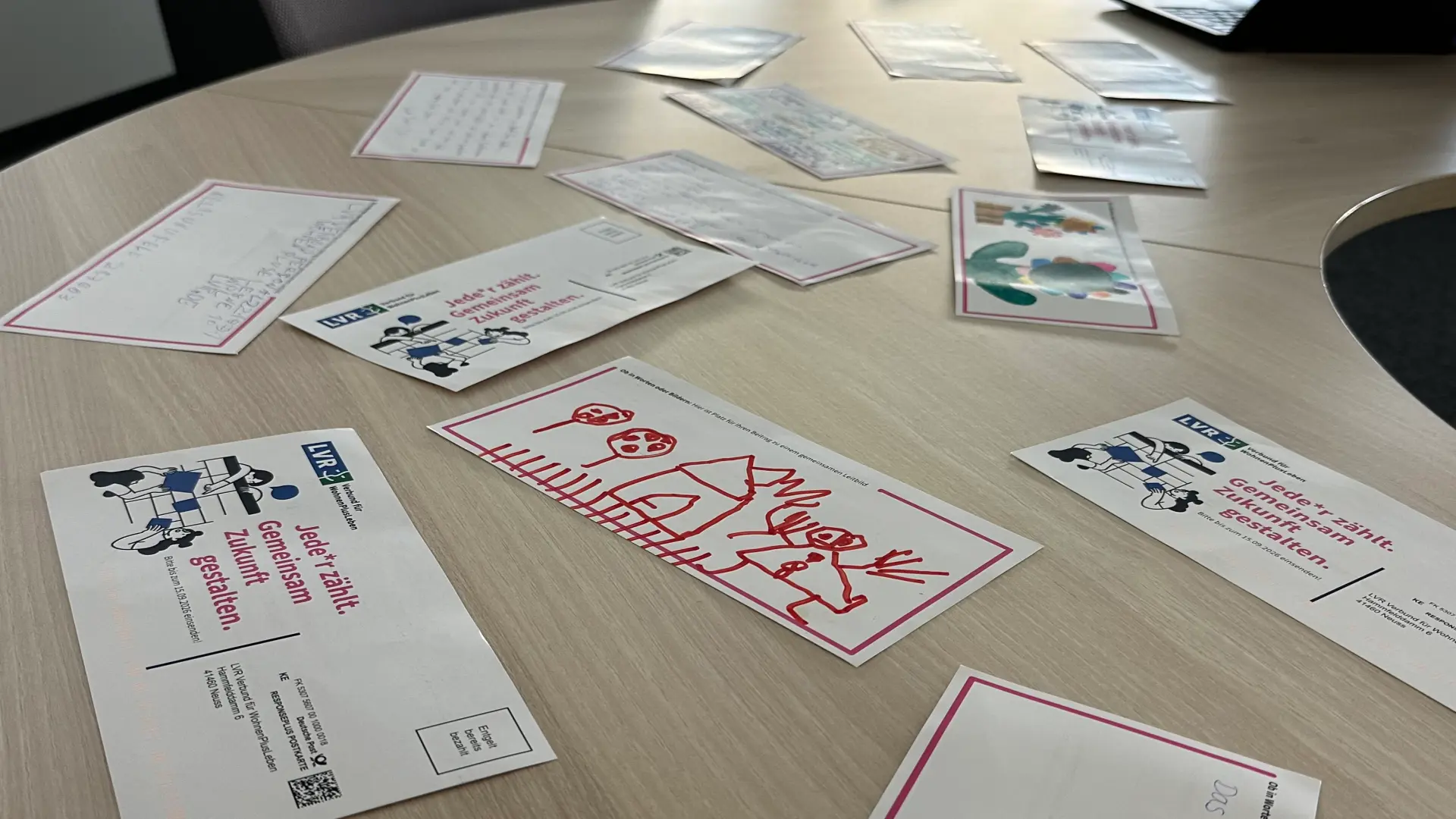 Viele verschiedenen Postkarten liegen auf einem Tisch