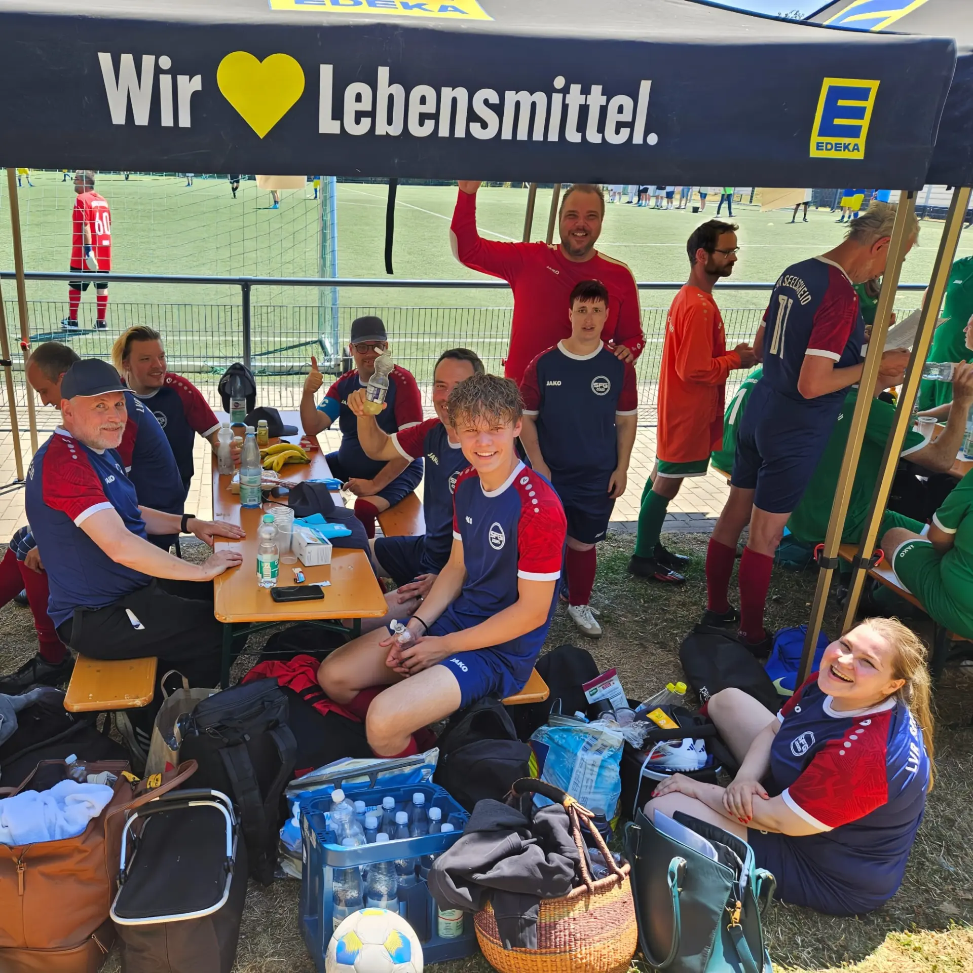 Gut gelaunte Mannschaft macht eine Pause unterm Pavillion.